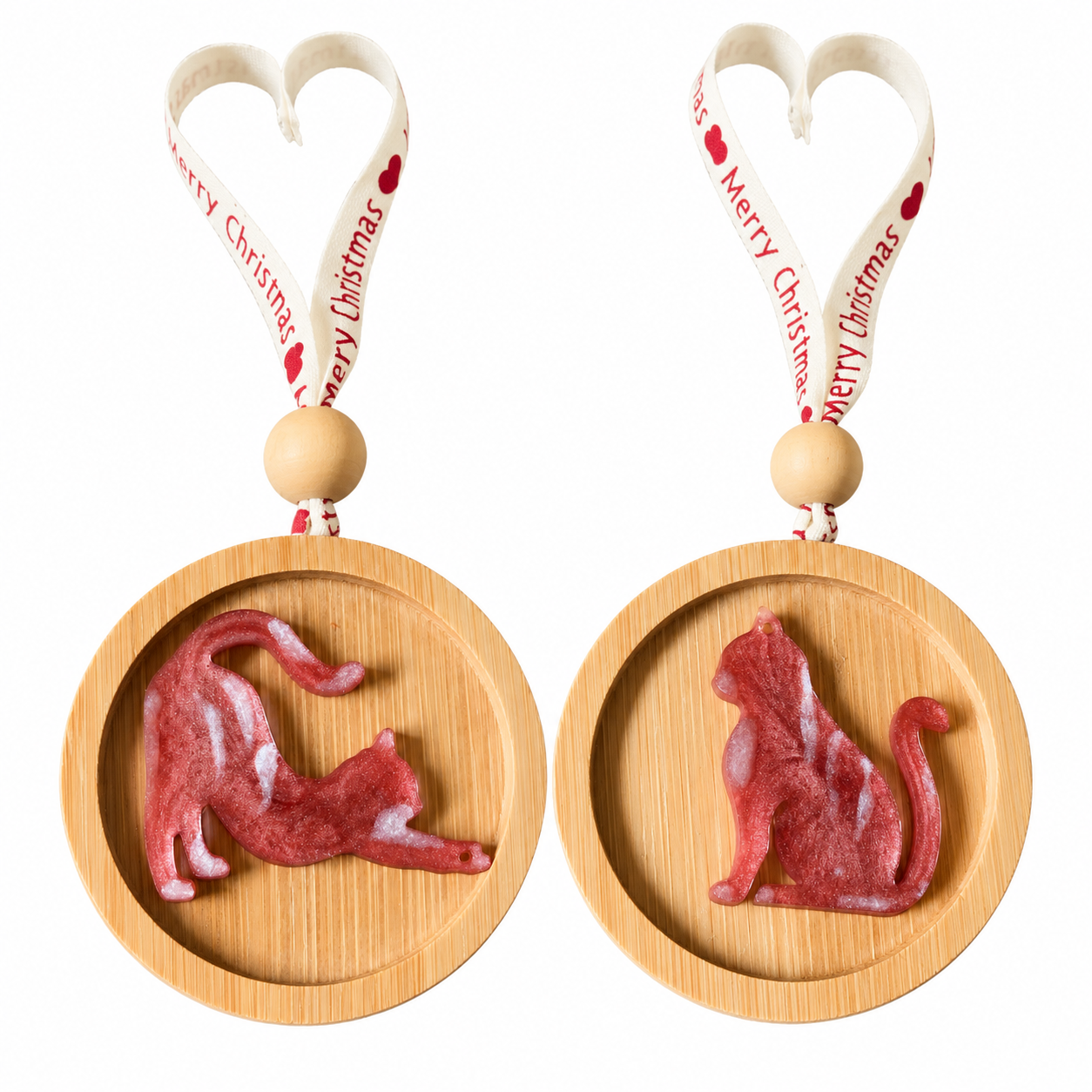 Two handmade ginger red resin cat Christmas decorations, sitting and stretching designs on round wooden ornaments with festive hanging ribbons, photographed on a white background.