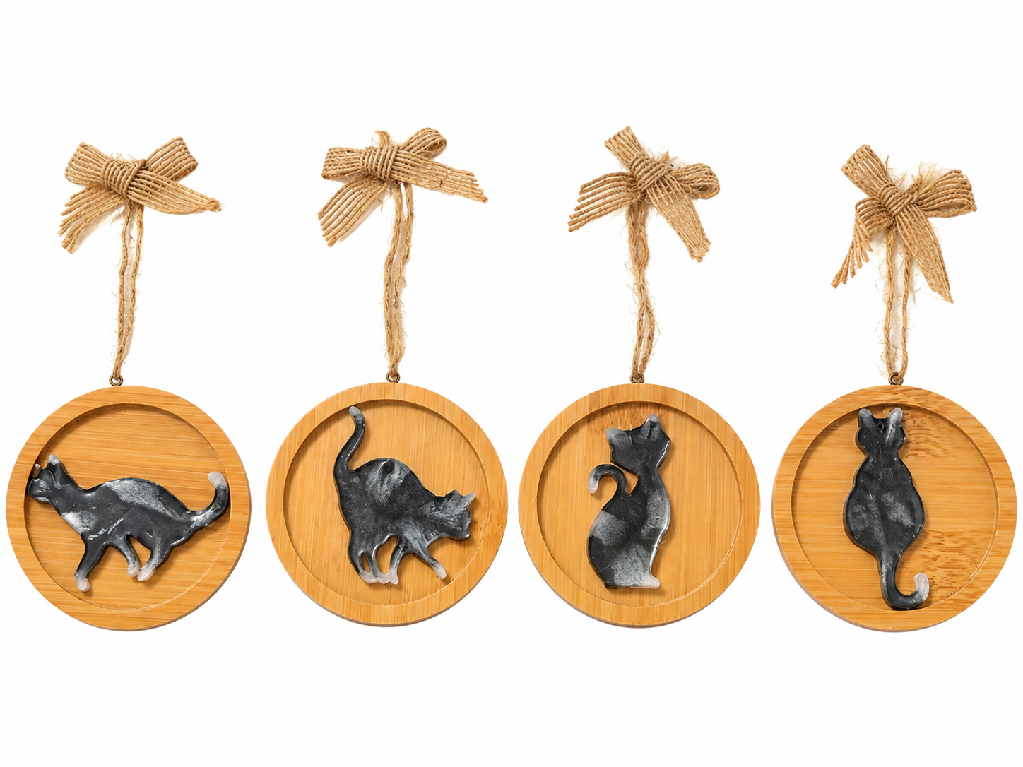 Four handmade black and white resin cat Christmas decorations on round wooden ornaments, finished with natural jute hanging loops and rustic hessian bows, displayed on a white background.
