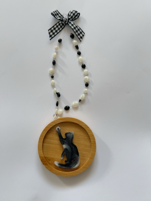 Handmade black and white marbled resin cat Christmas decoration with one paw raised, on a 6.5 cm round wooden ornament, finished with decorative beads and black and white gingham bow.