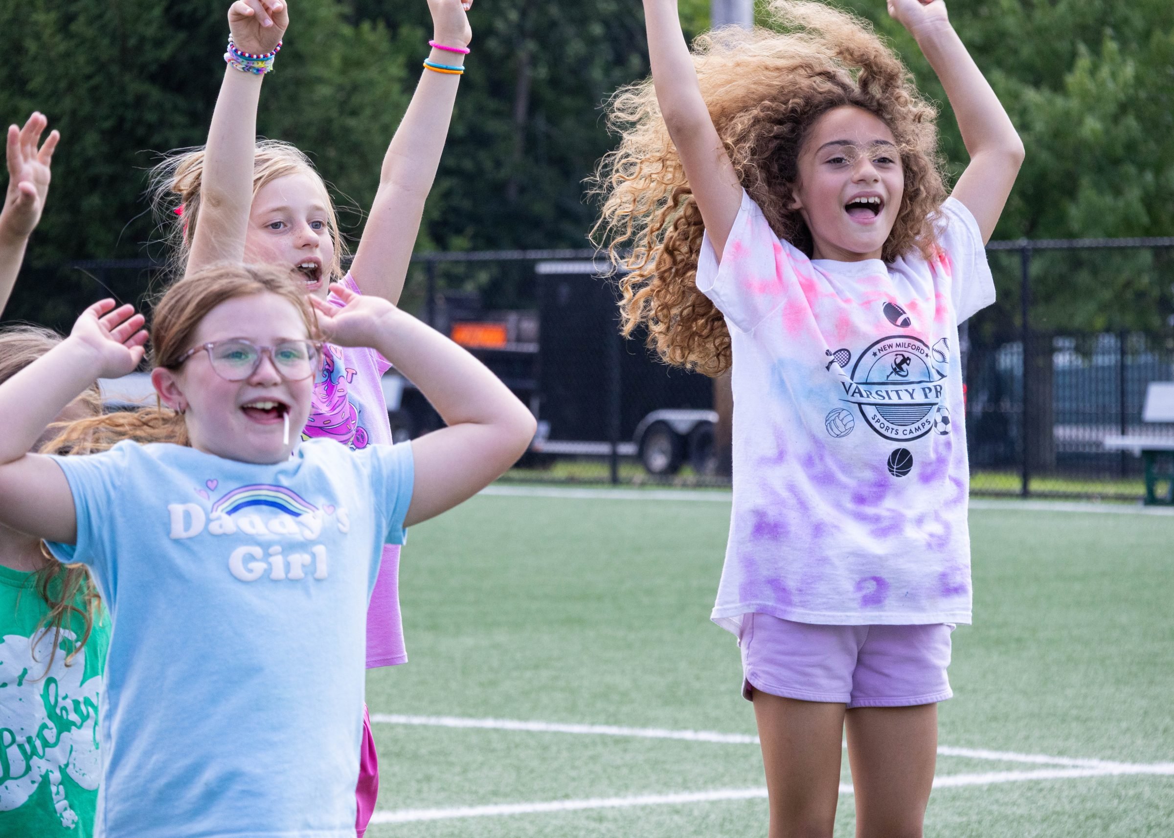 Campers jumping and cheering on the field