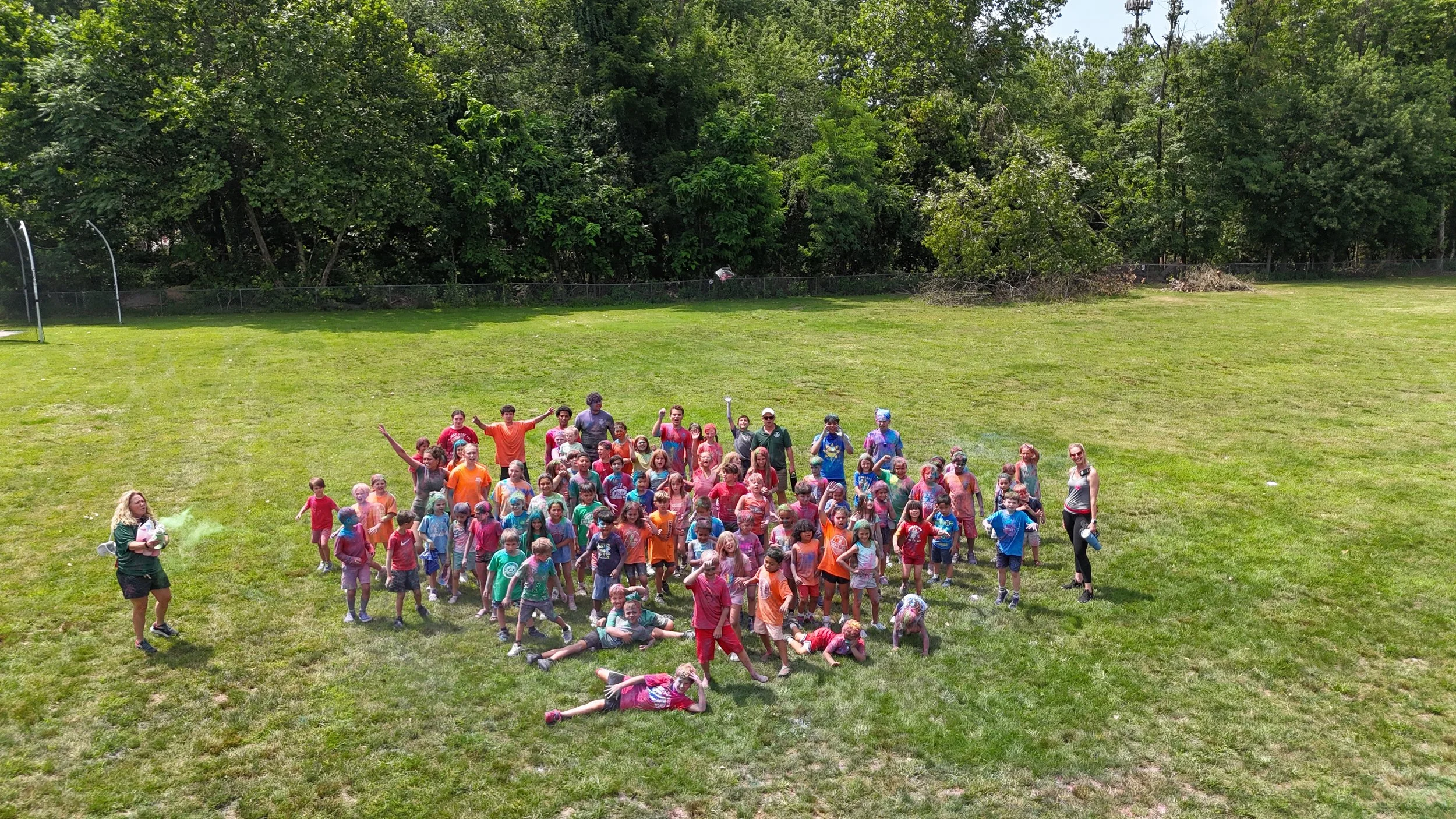 Campers cheering with arms up on the field