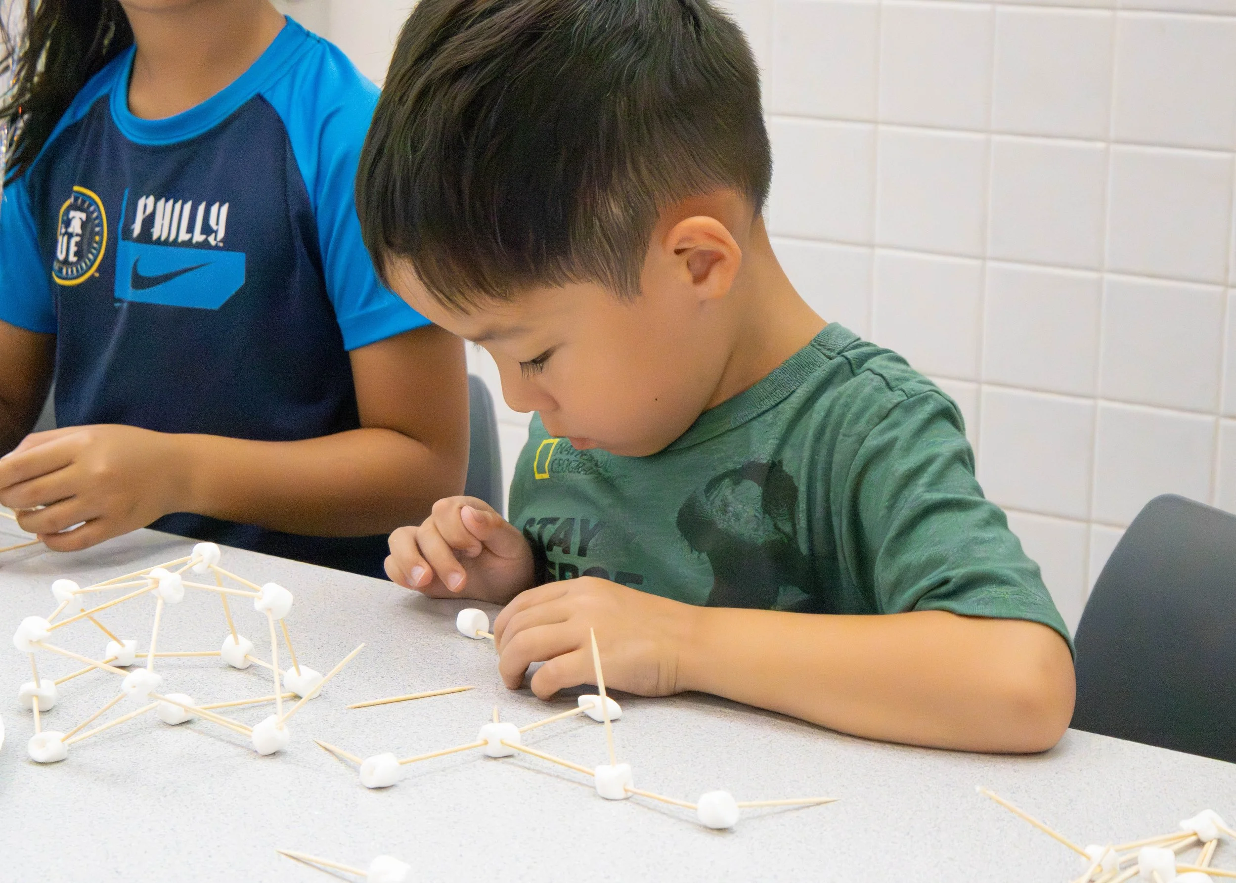 Campers building a project at the STEM table