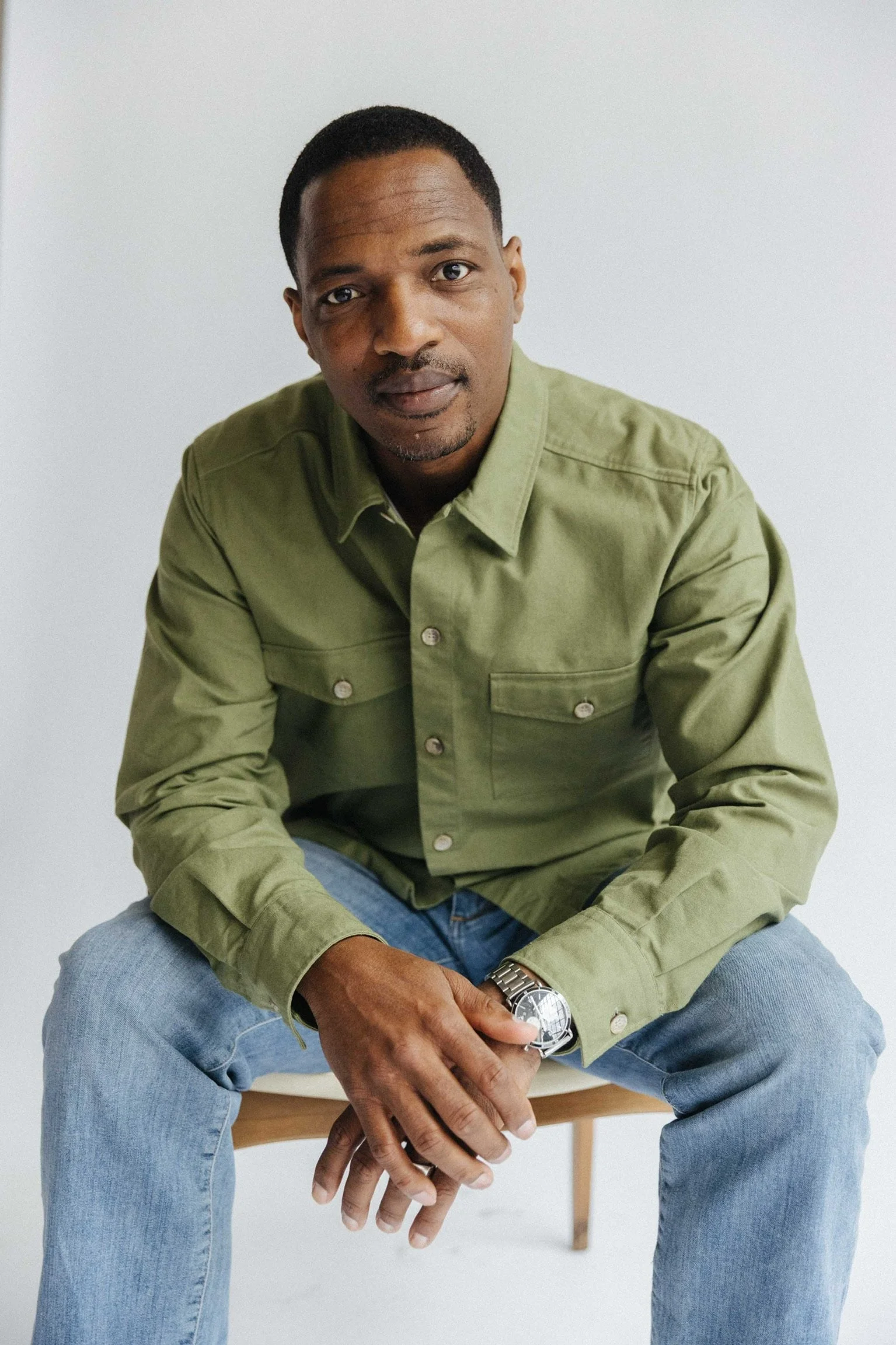 Pastor Norflette Shumake, Detroit preacher and speaker, seated in a green shirt against a light background