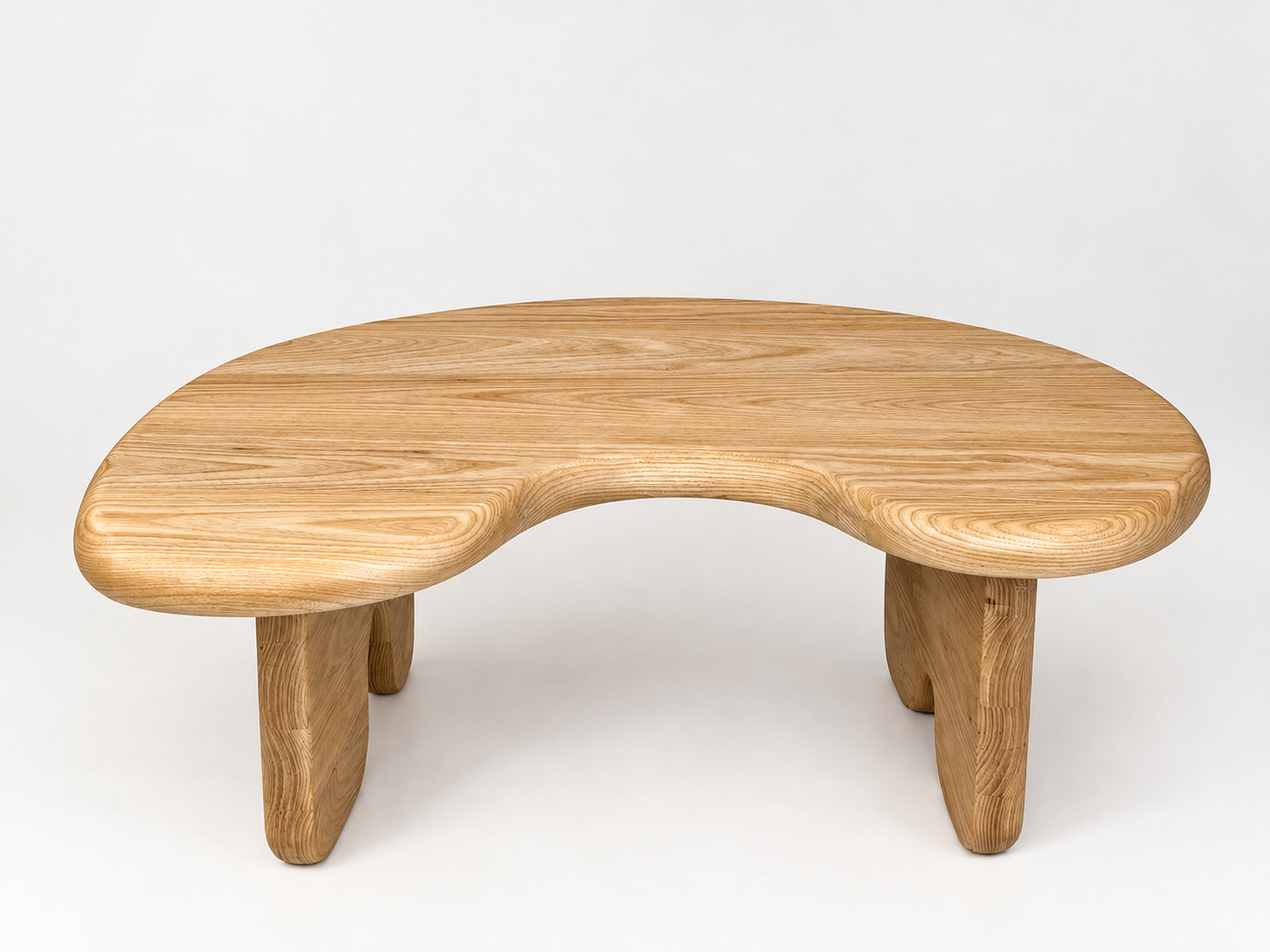 A wooden kidney-shaped table with three legs, placed against a plain white background.