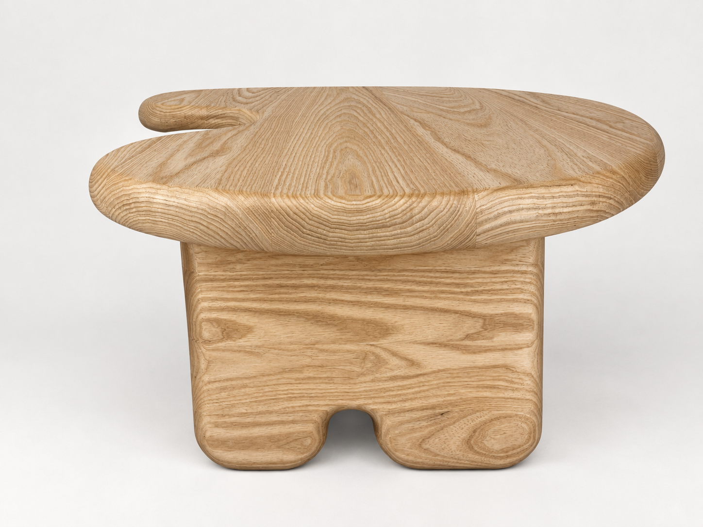 A wooden stool with a square base and an irregularly shaped round top.