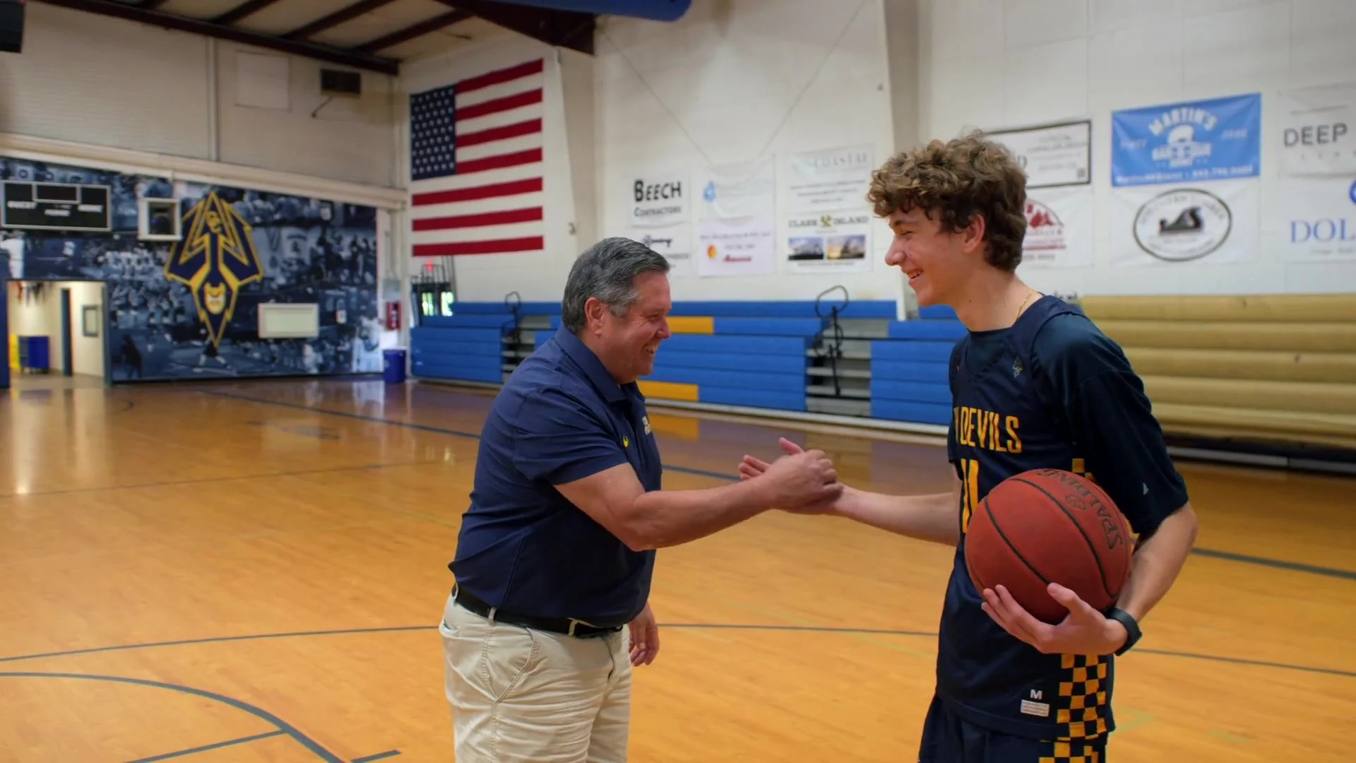 A Charleston Collegiate coach connects with a student on the basketball court