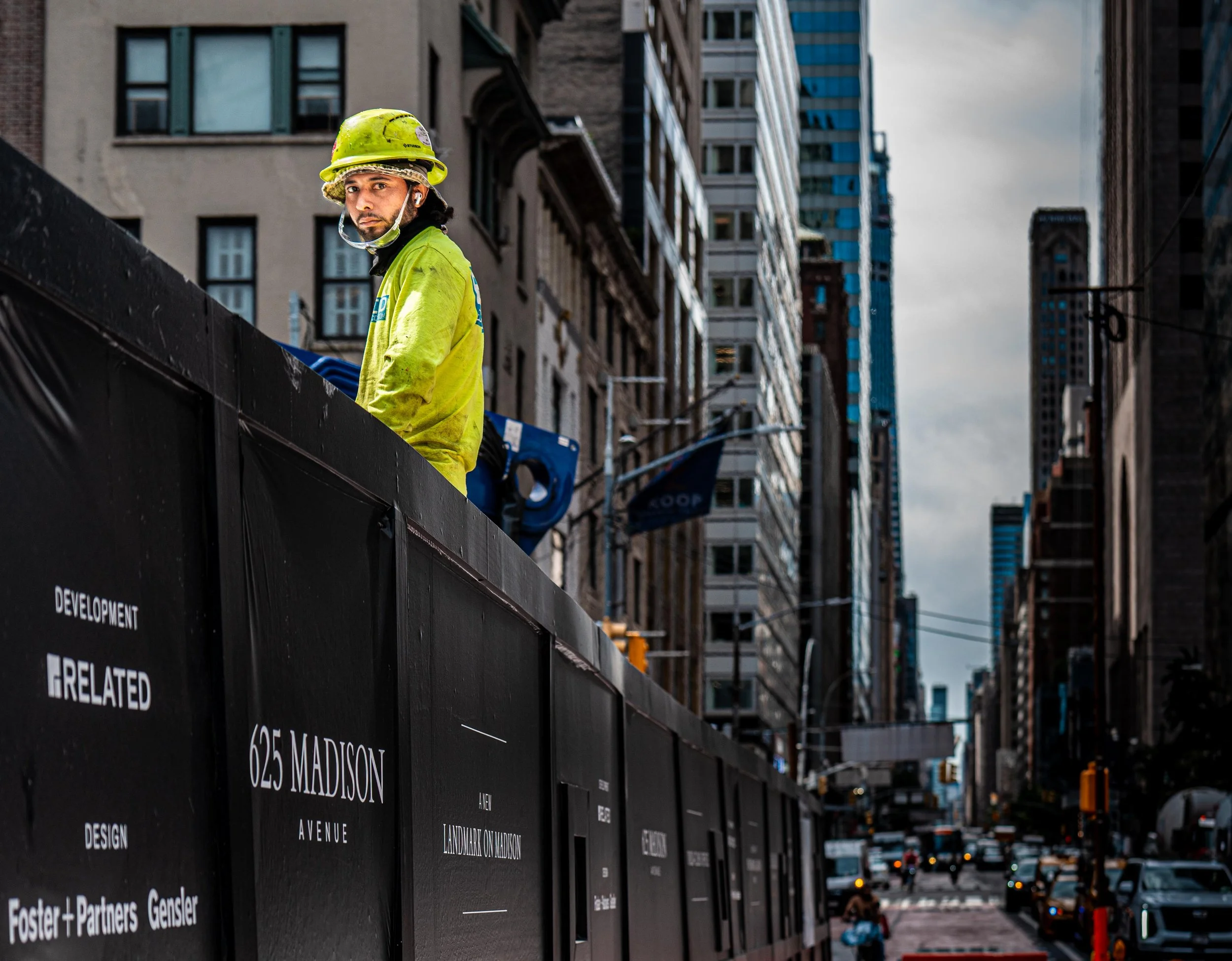 man sitting on construction fence Madison Avenue.jpg