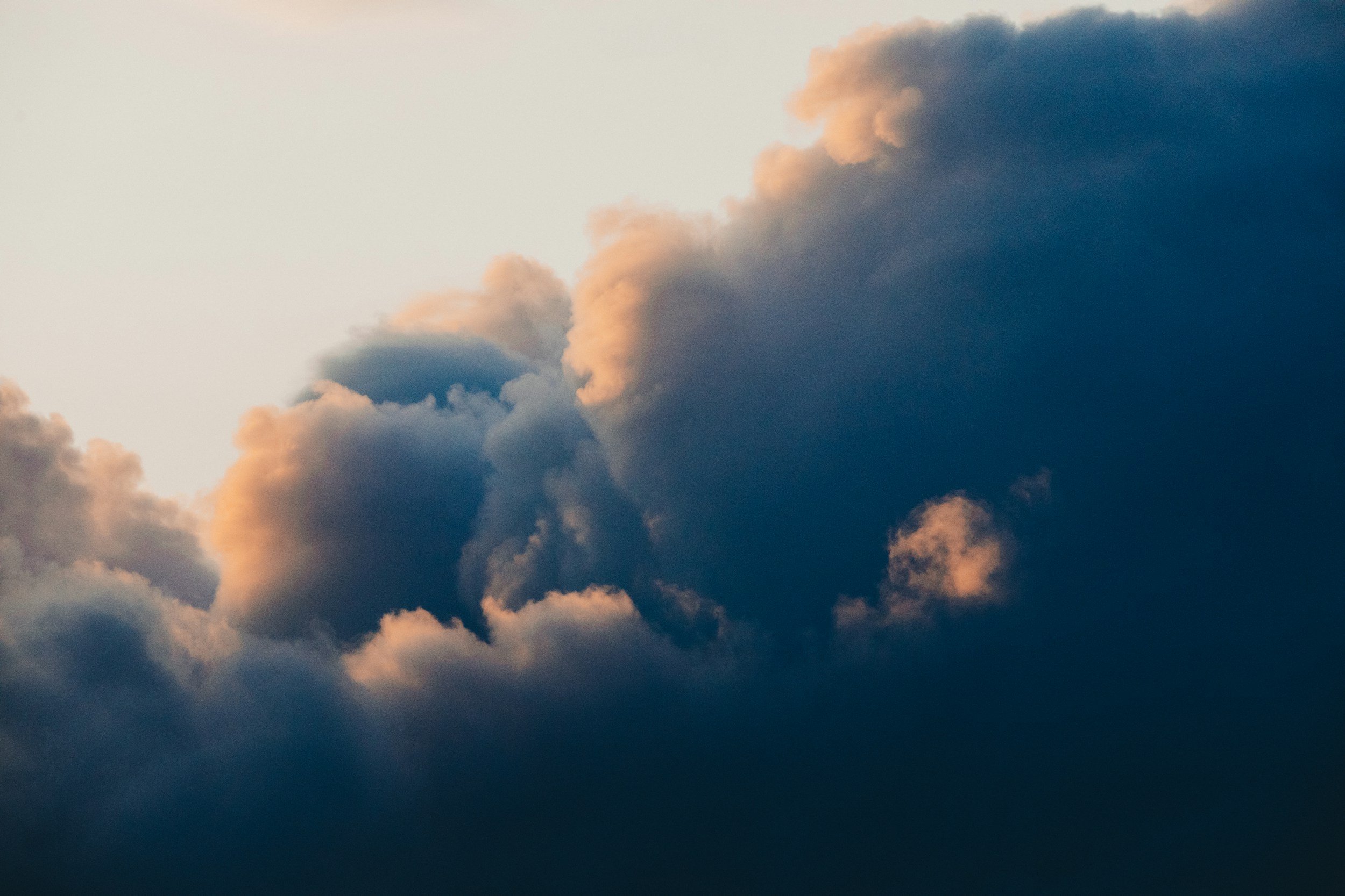 Sky filled with dark and light clouds during sunset or sunrise.