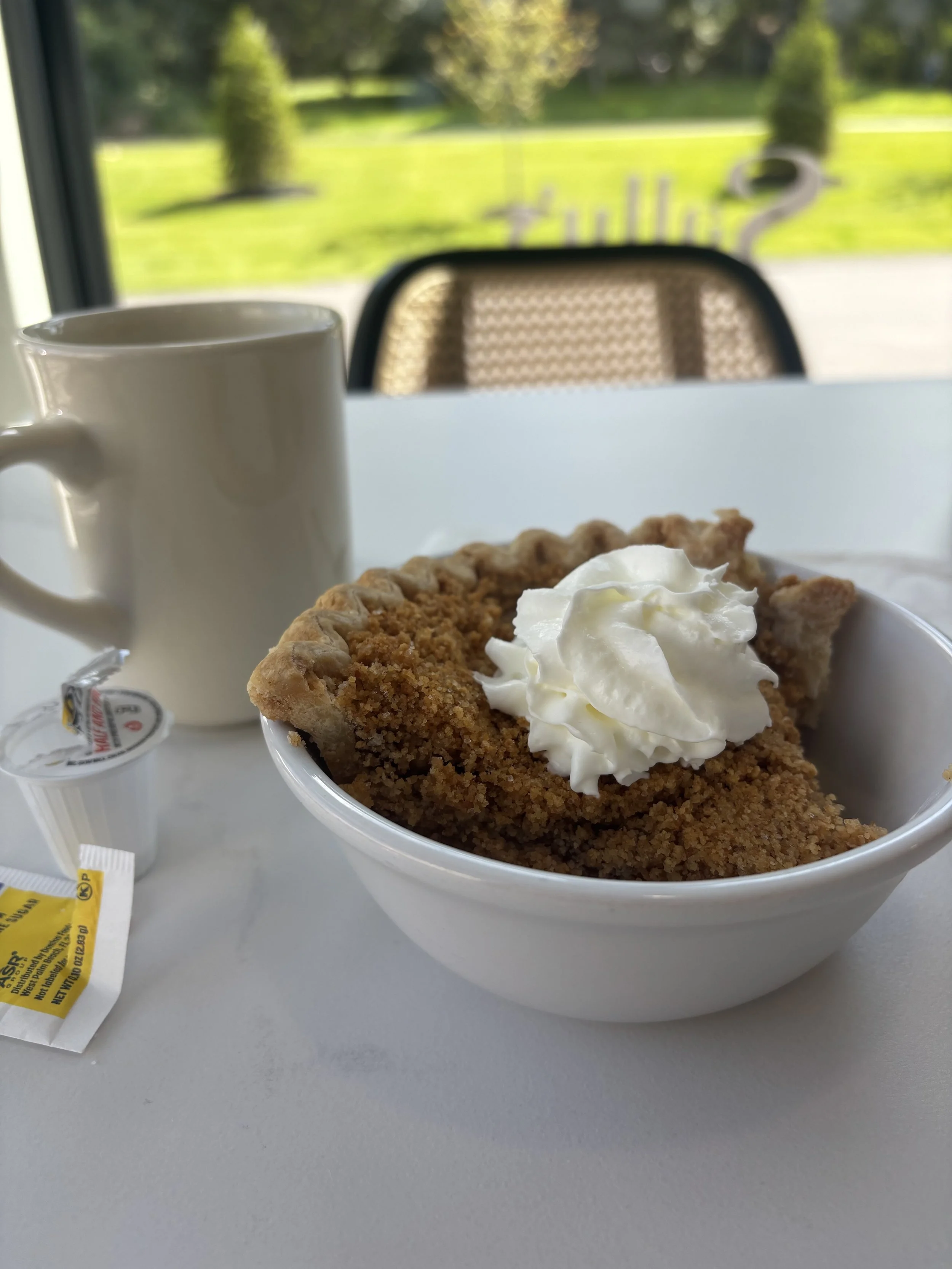Slice of apple pie served with a hot mug of coffee at Sally’s Diner