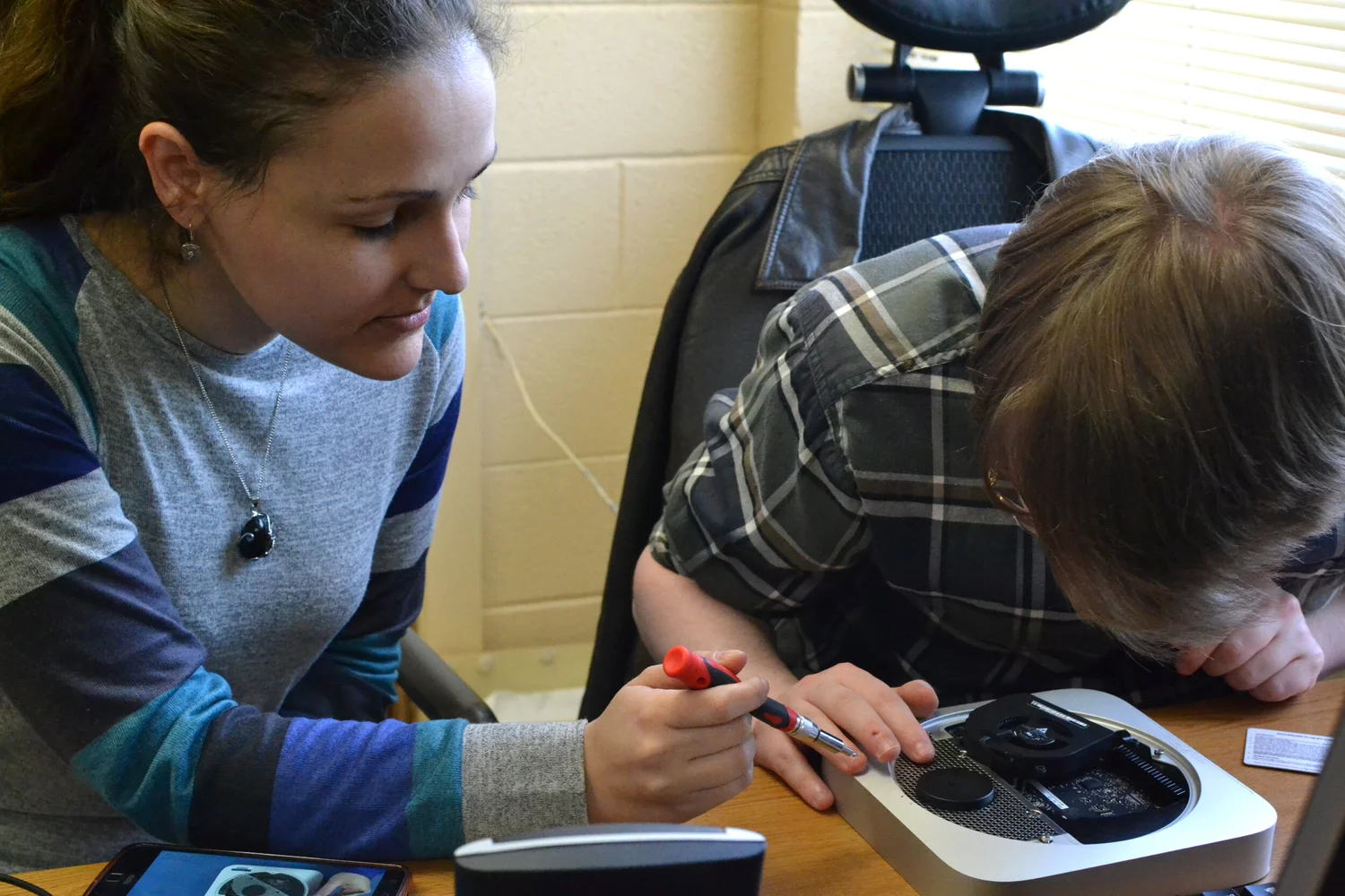 Photo of client and teacher working on mini PC