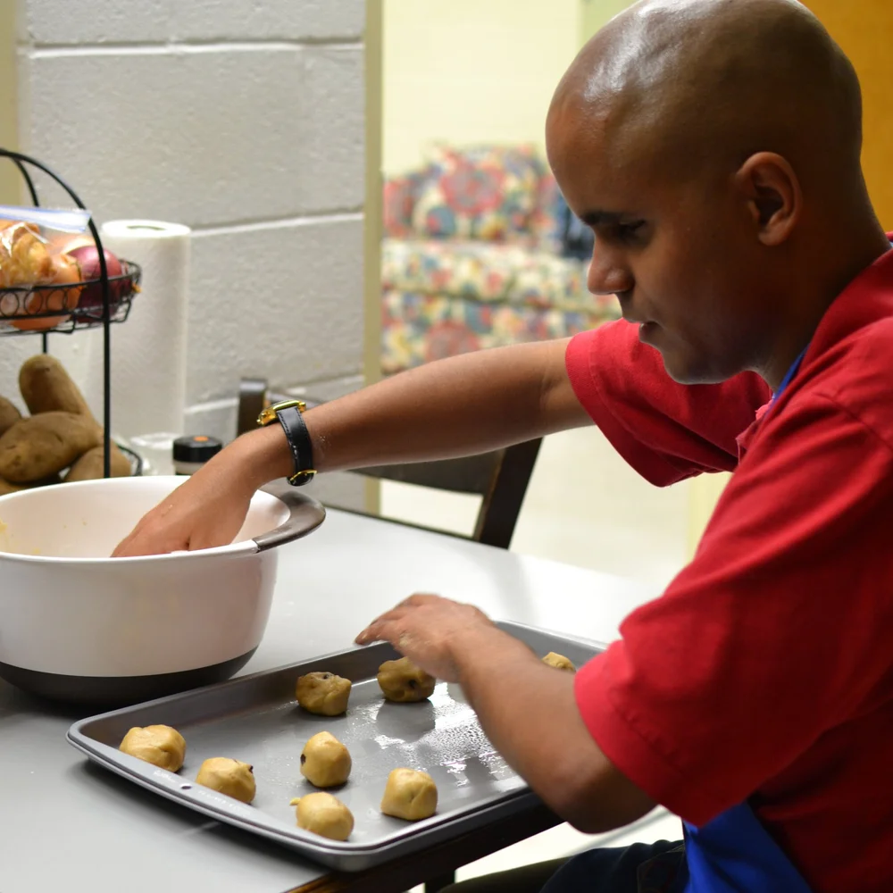 Client putting cookie dough on a tray
