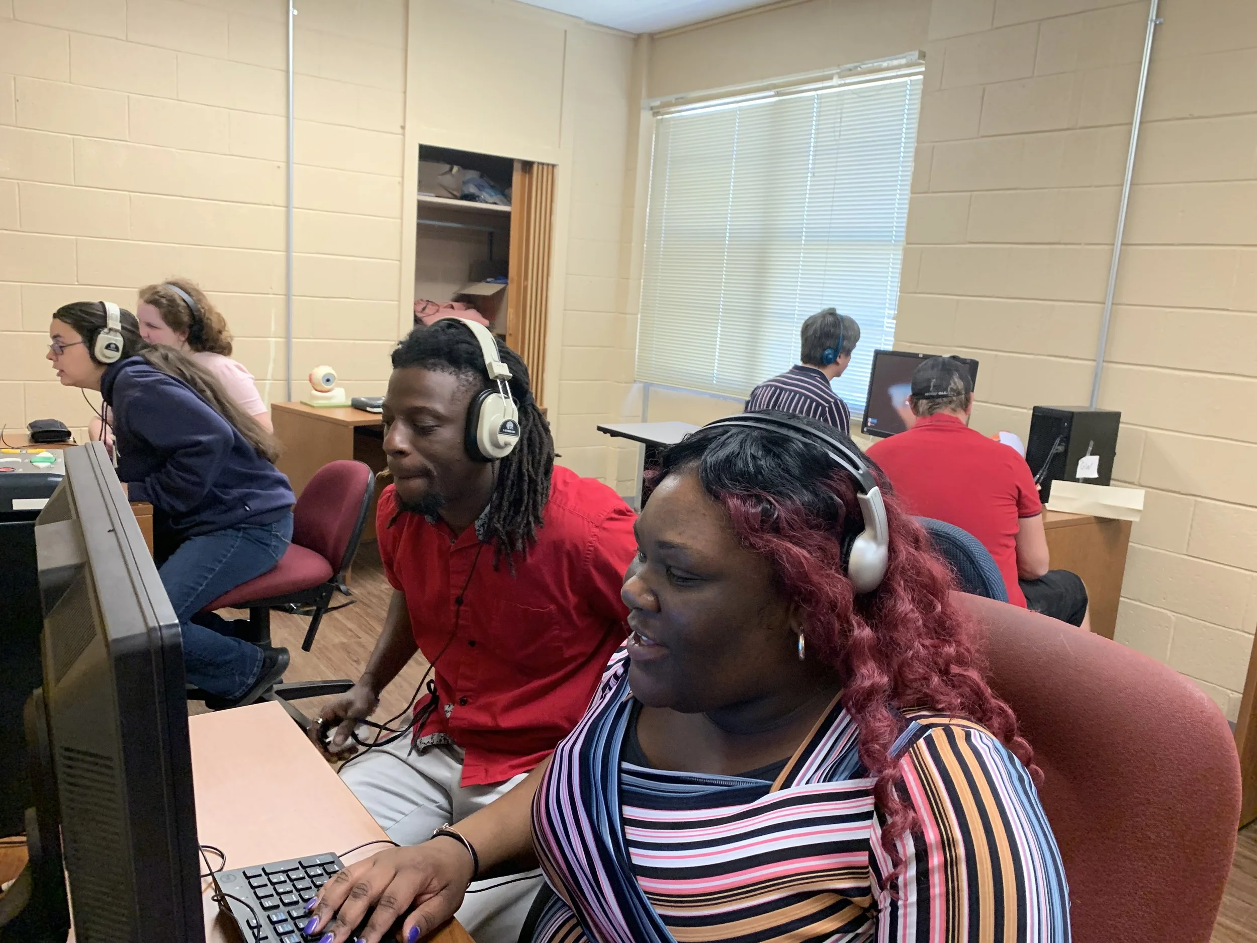 Class with multiple clients and student teachers working together at computers