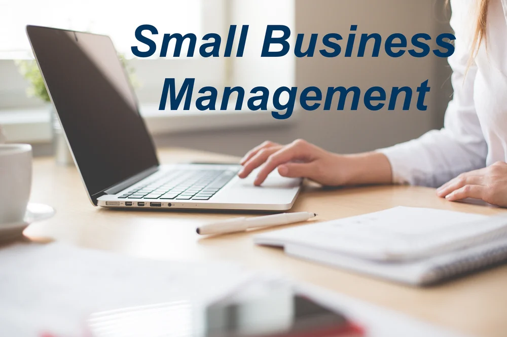 person typing at a laptop with blue text “small business management”