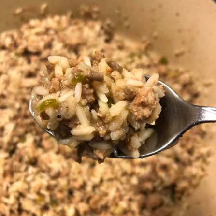 A spoonful of rice dressing, ground meat, and vegetables.