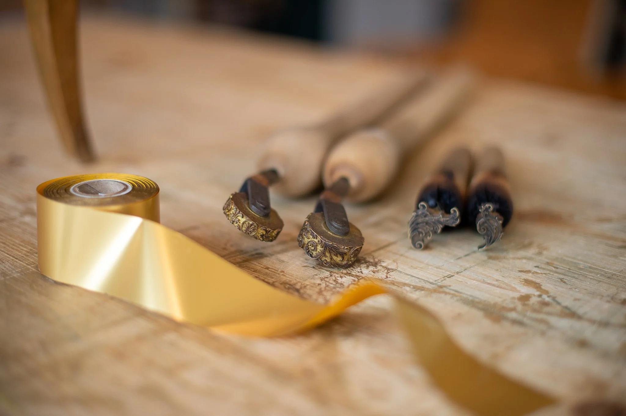 Outils de gravure avec deux forets à billes, un marteau à poinçon et un ruban or.