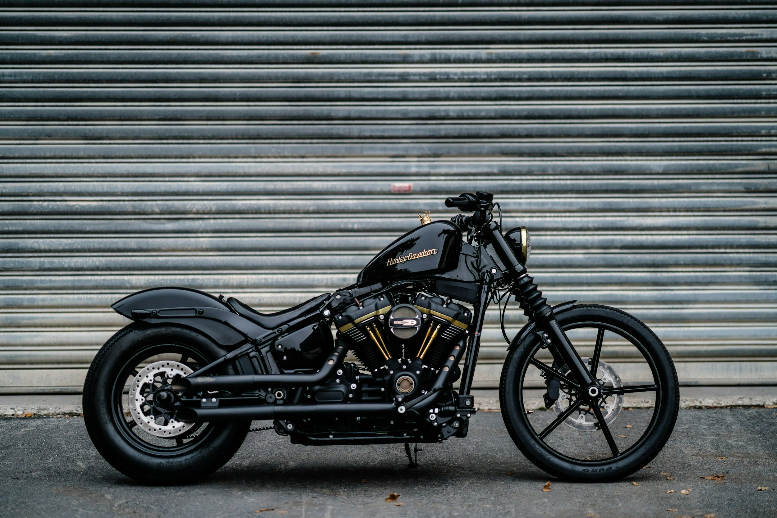 Black Harley Davidson motorcycle parked in front of a corrugated metal garage door.