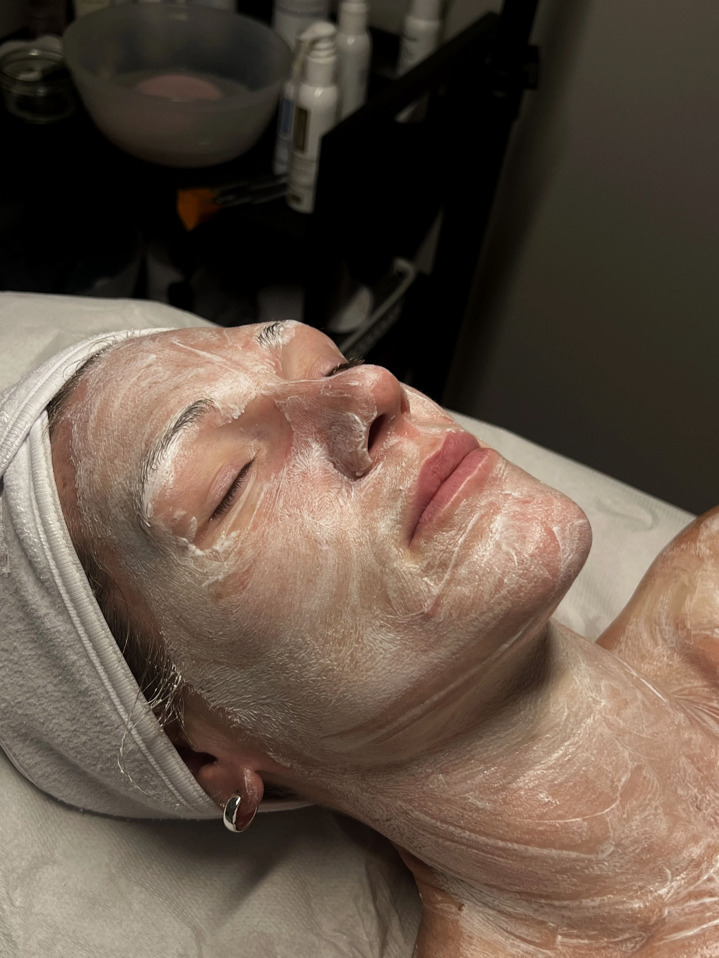 Client relaxing with a facial mask during a skin treatment at Beau.t.
