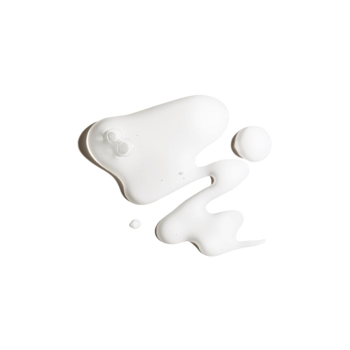 Une éclaboussure de liquide blanc, semblable à du lait ou de la crème, sur un fond blanc.