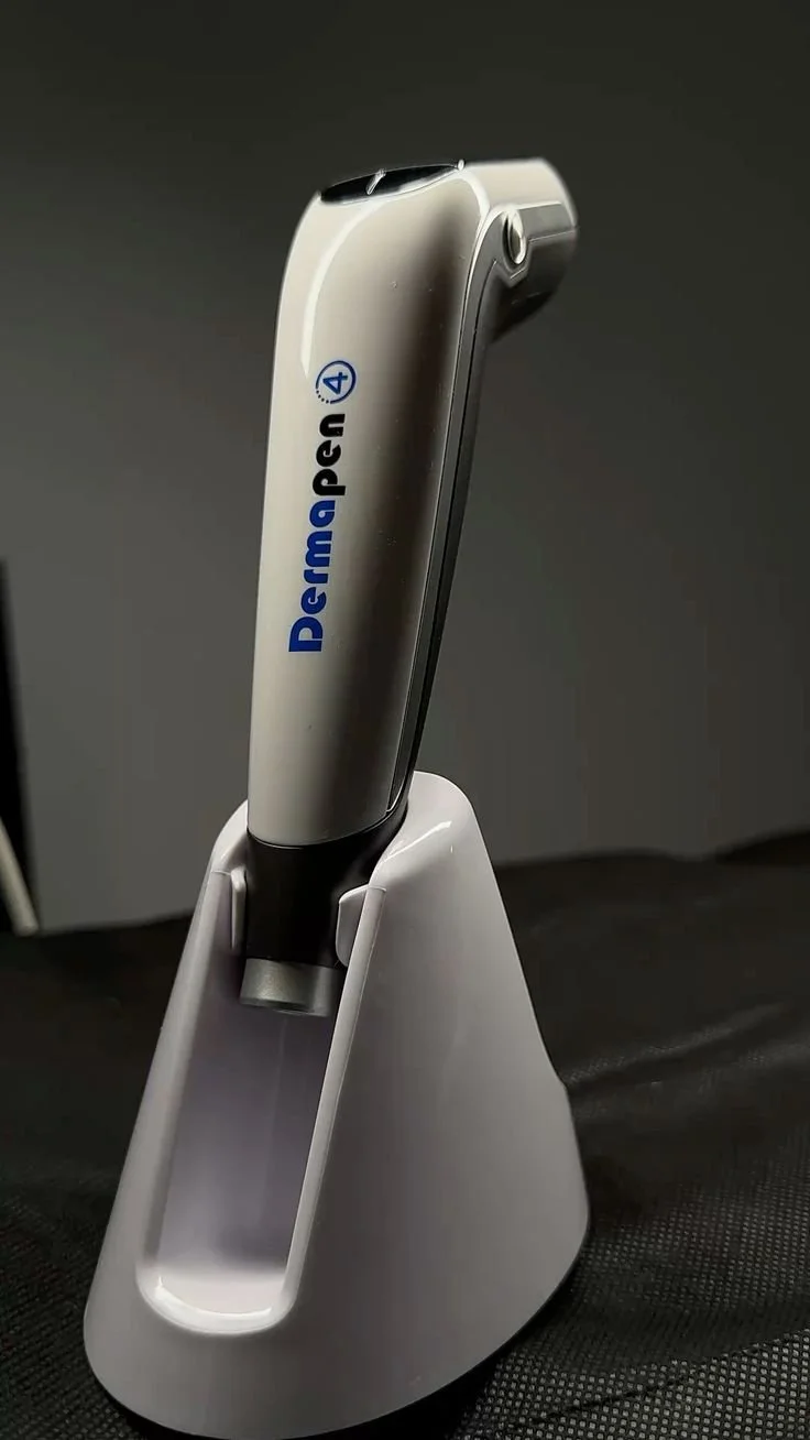 Appareil médical, probablement une otoscope dans un support blanc sur un fond sombre.