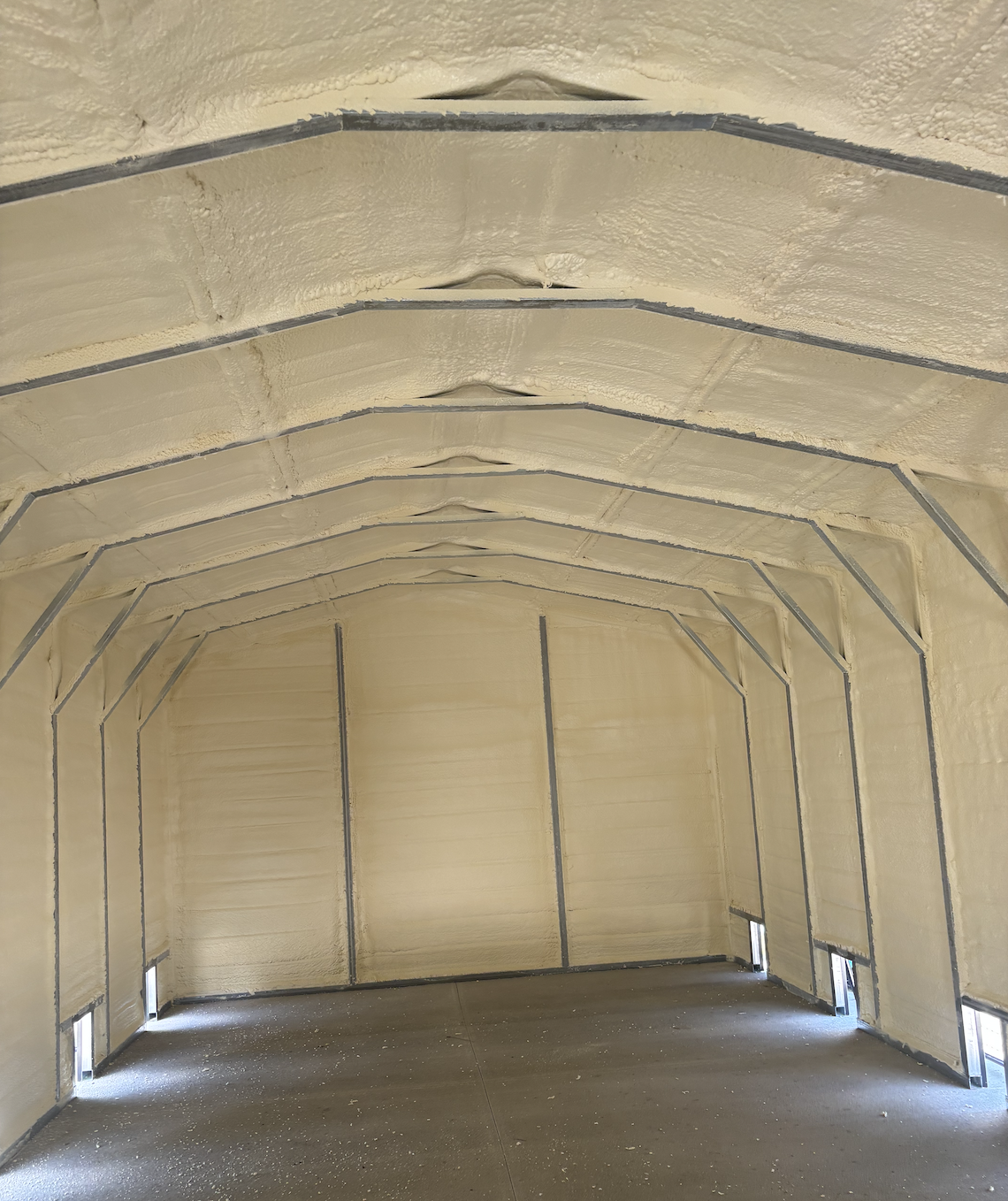 Interior view of a large enclosed space with insulated, arched ceiling and walls, and small rectangular vents at the bottom.