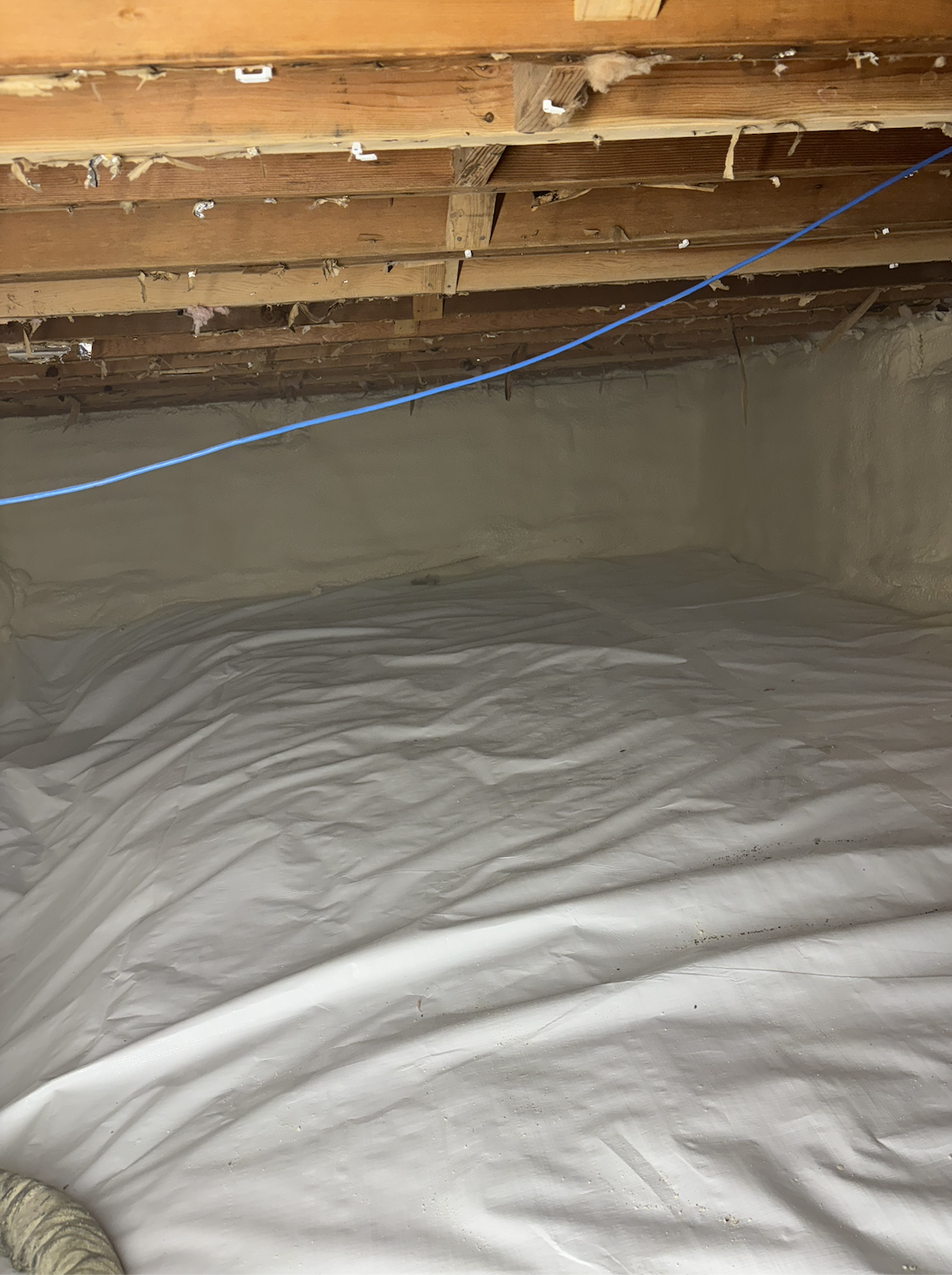 Insulation and plumbing wiring in an unfinished ceiling of a building under construction.