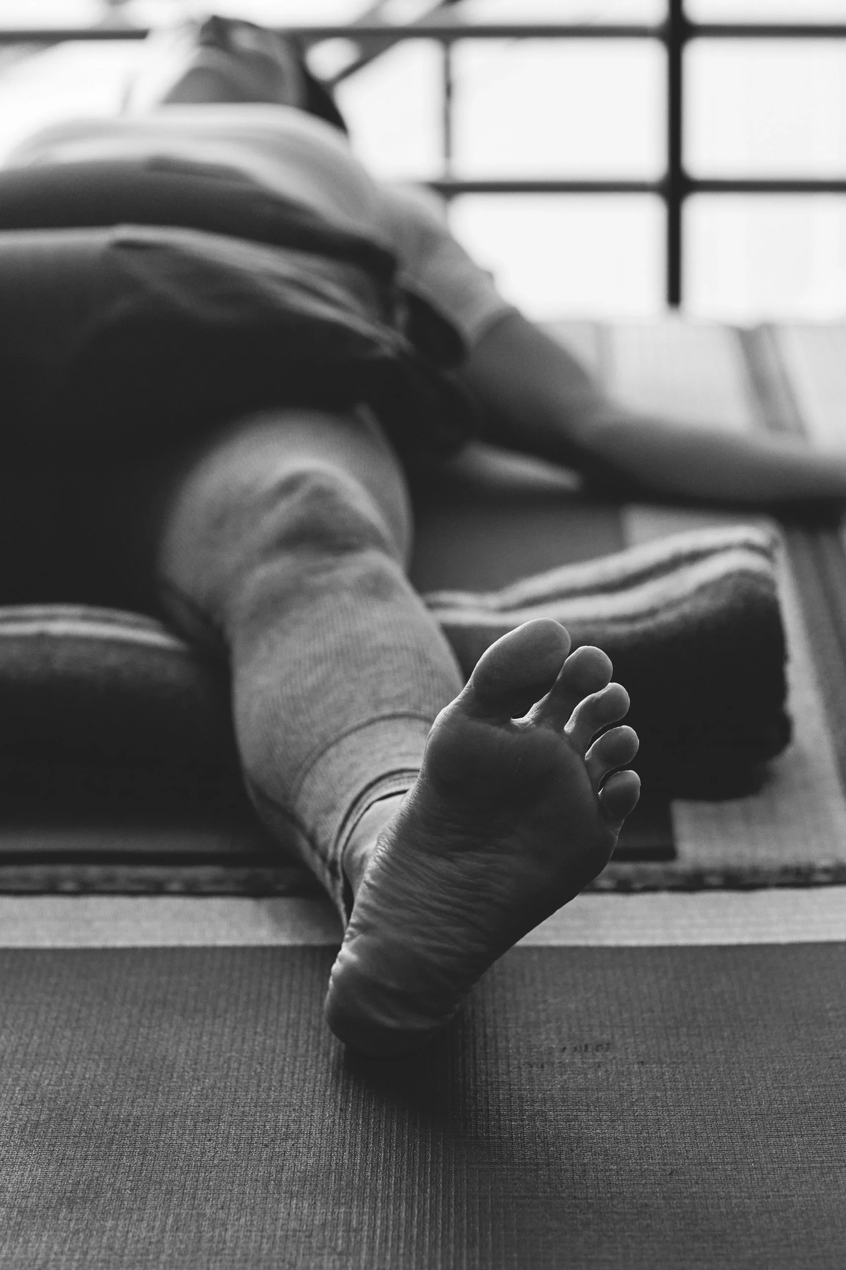 Supported reclining yoga pose on bolsters, seen from the feet