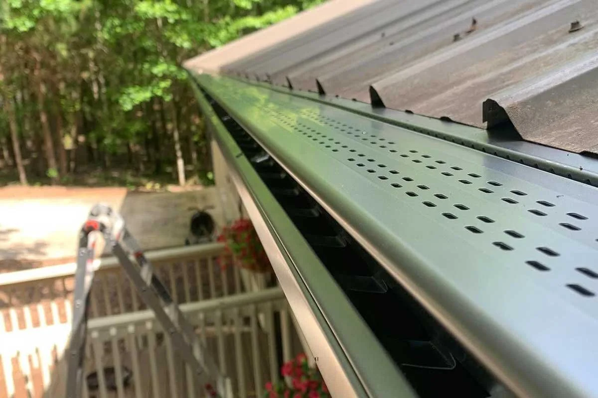 Close-up leafx gutter protection on a home, with trees in the background.