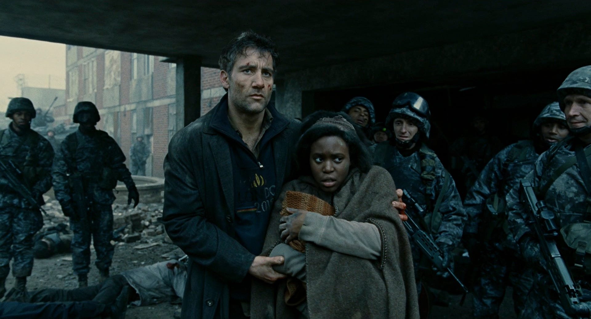 Theo and Kee carry the newborn through Bexhill as soldiers lower their weapons and stare at the child.
