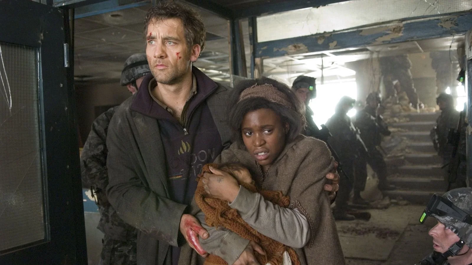 Theo and Kee shelter with a newborn amid armed soldiers in a damaged building in Children of Men (2006).