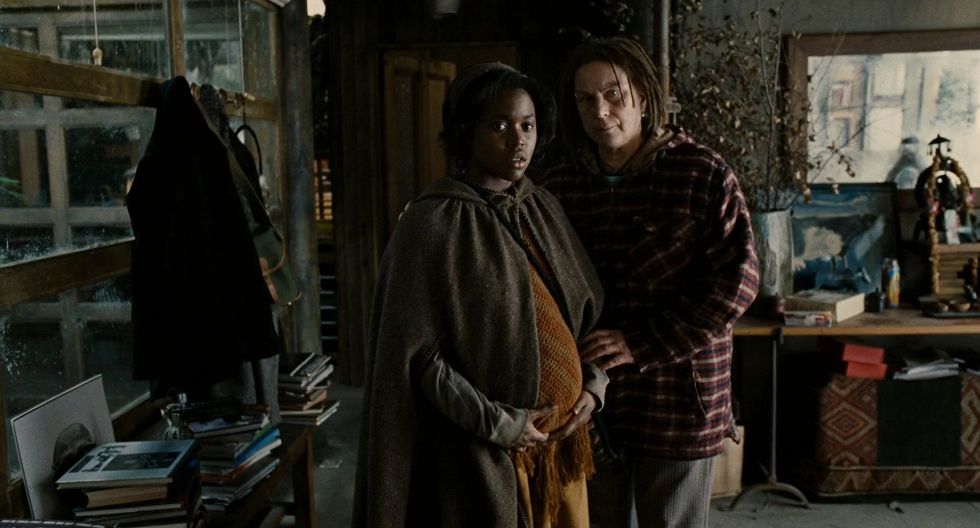 Kee and Miriam stand in the doorway of Jasper’s woodland home as Theo and Jasper look on.
