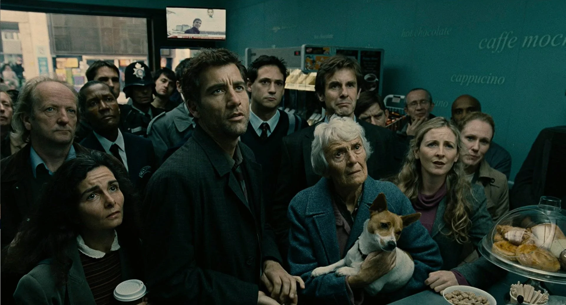 Theo Faron stands in a crowded coffee shop, reacting to the news of Baby Diego's death.