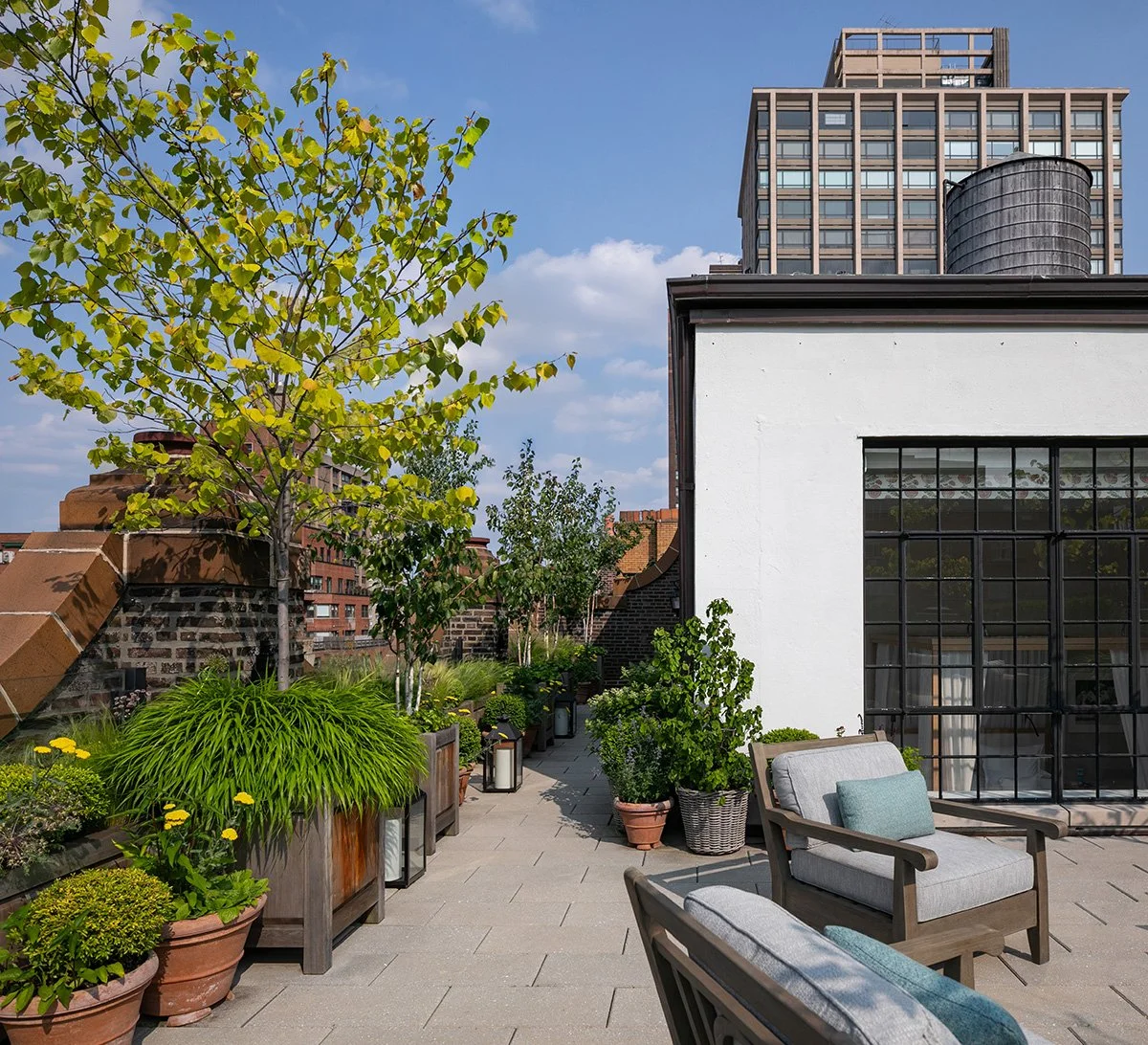 Terrace with potted trees and armchairs beside the penthouse, Upper East Side Penthouse