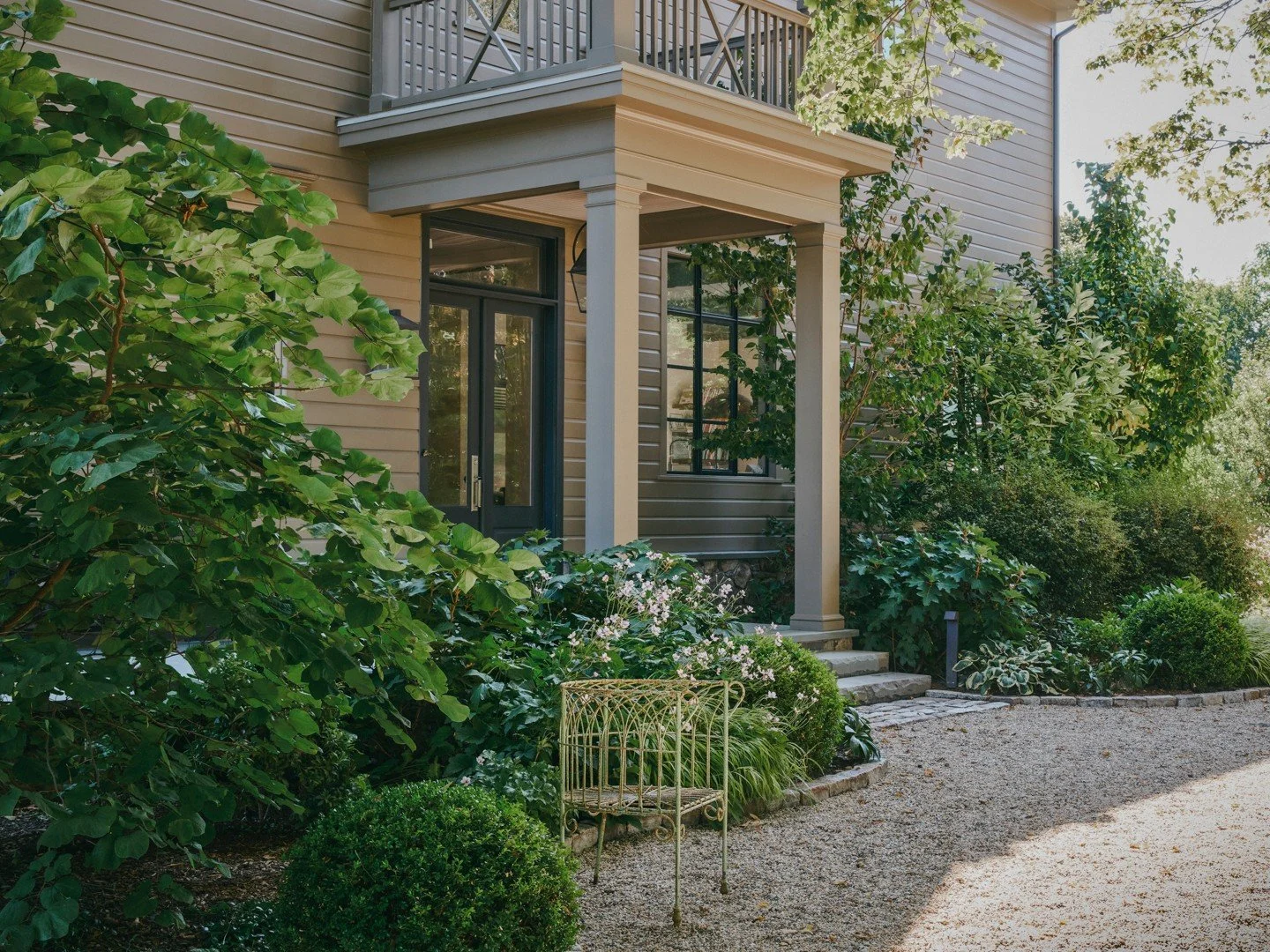 Swipe for before ~ Mature foundation planting helps bring the scale of the house down to a more human level, allowing the architecture to settle naturally into its landscape.

Generous layers of Redbud, Lilacs and Magnolia establish a strong framewor
