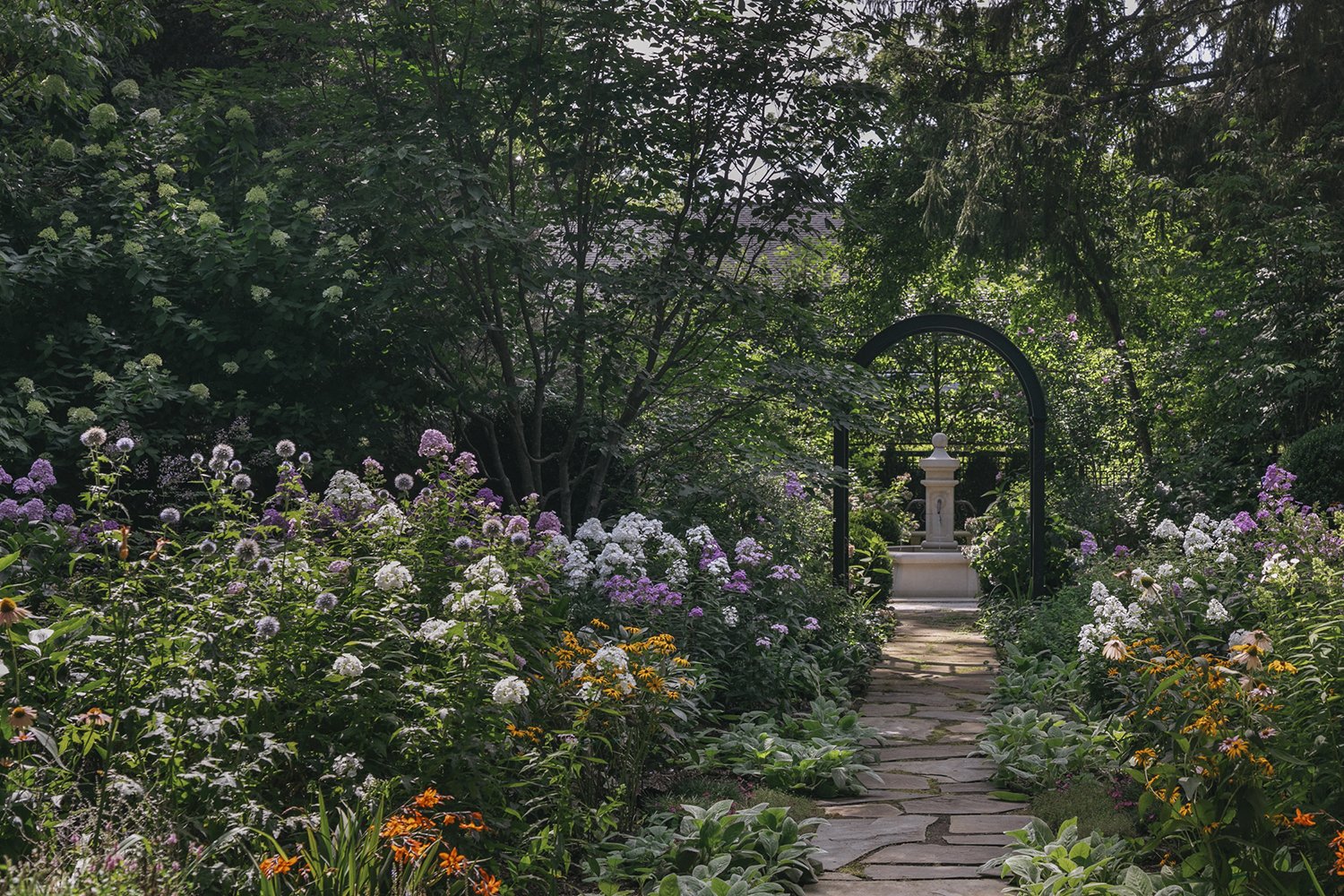 Stone path through phlox and lilies to a black steel garden arch, Historic Garden, Shrewsbury NJ