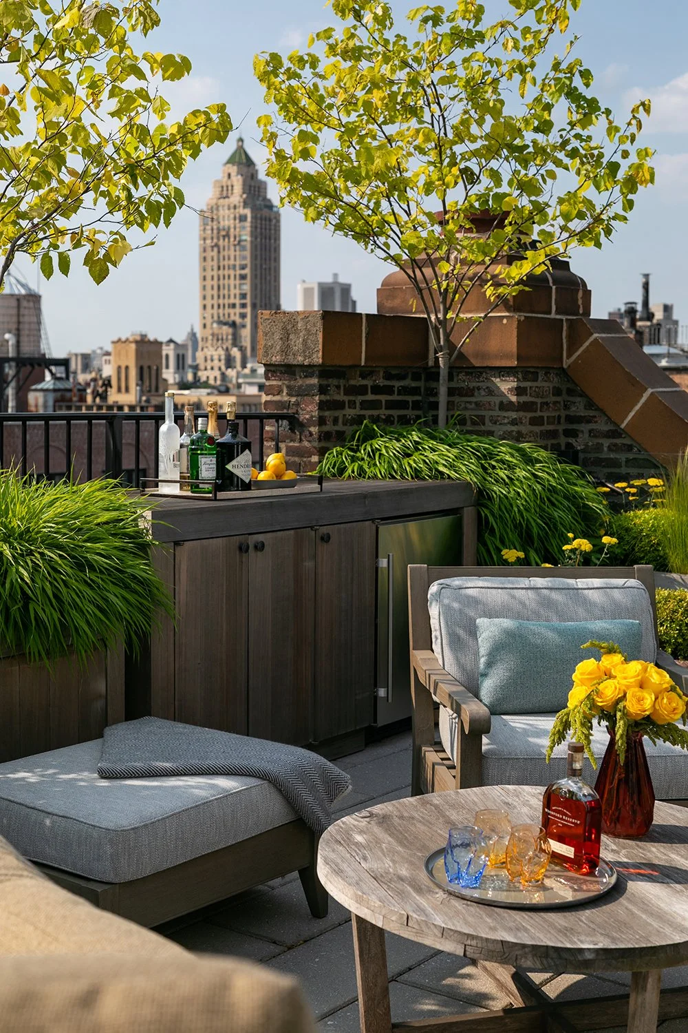 Bar cabinet, lounge chairs and a timber coffee table with the skyline beyond, Upper East Side Penthouse