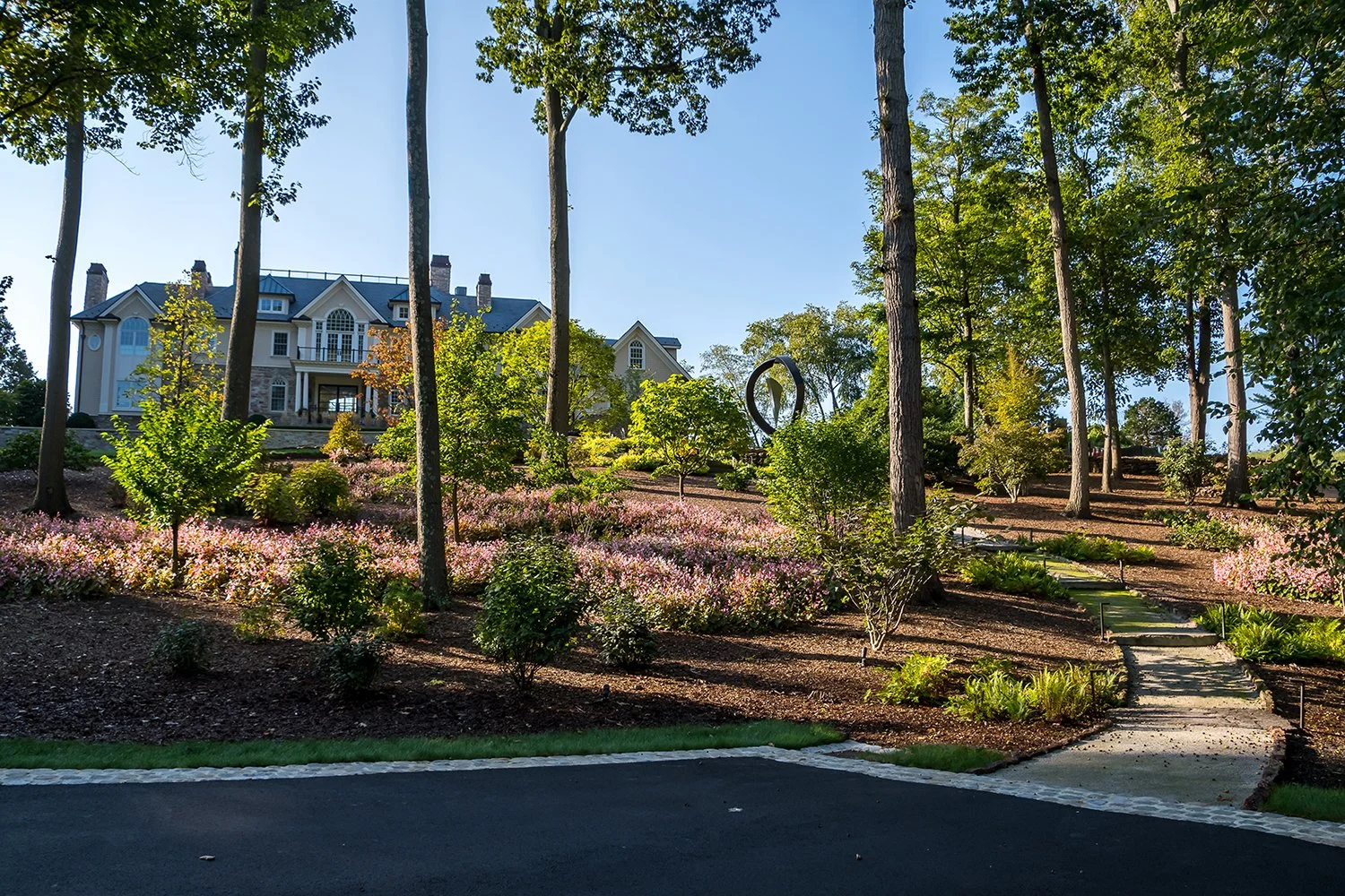 Woodland garden with sculpture beneath tall trees, Riverfront Estate, Navesink River