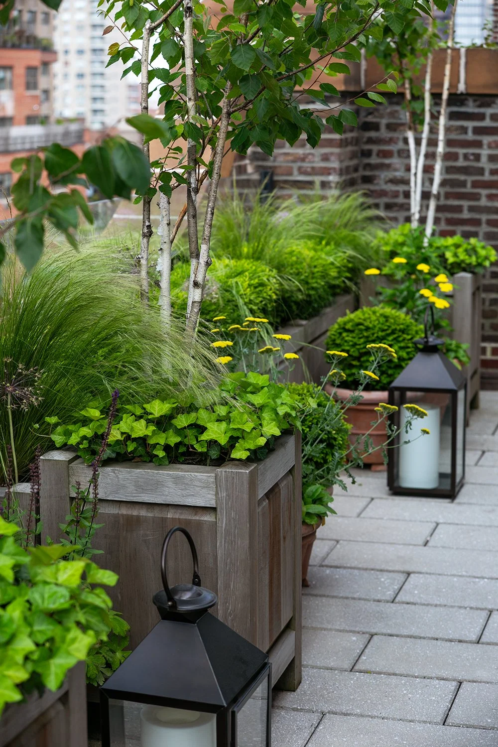 Timber planters and a lantern on the stone-paved terrace, Upper East Side Penthouse
