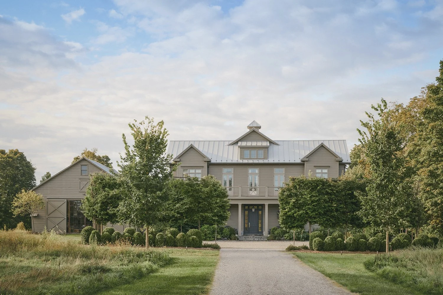 Gravel drive between pleached Linden trees leading to the house, Hudson Valley Estate, Rhinebeck