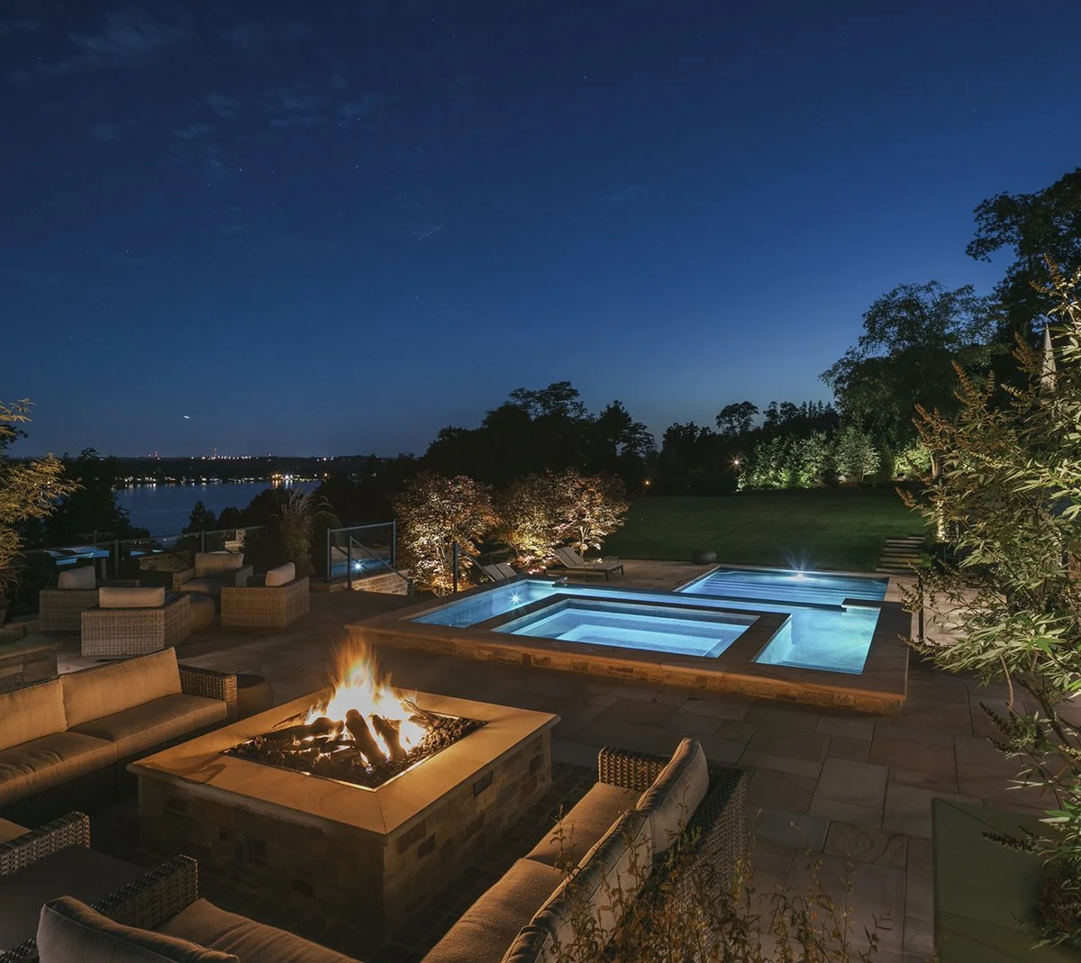 Fire pit and spa lit at night above the river, Riverfront Estate, Navesink River