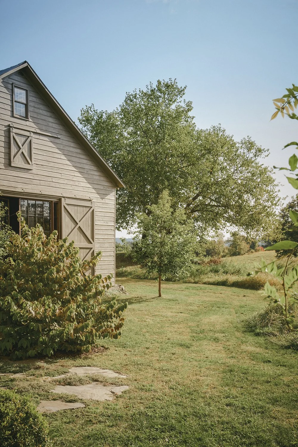 Barn framed by mature trees and planting, Hudson Valley Estate, Rhinebeck