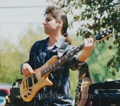Person playing a bass guitar outdoors