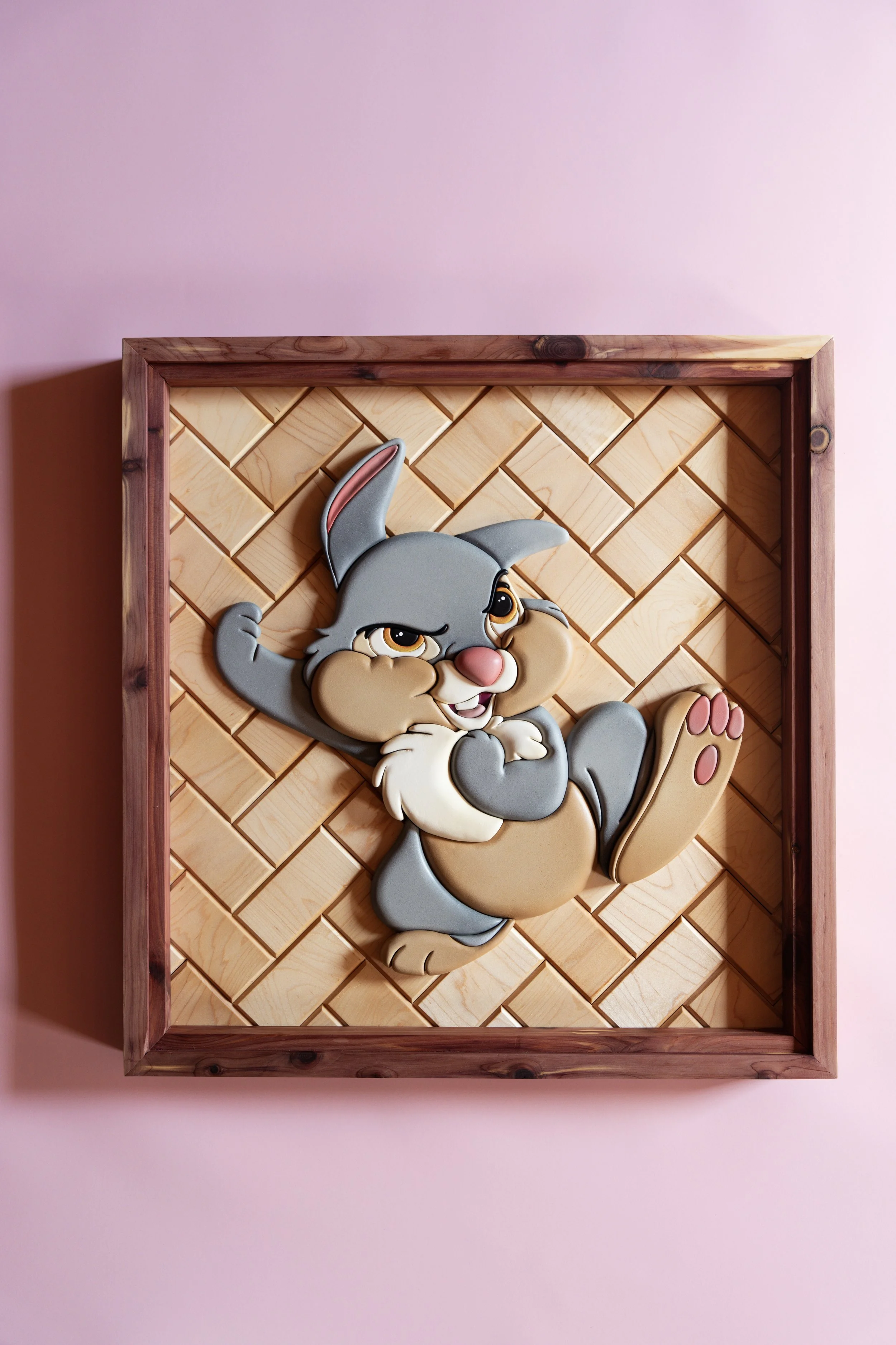 Thumper from bambi wood art. Wall decor with a 3D cartoon bunny animal made of layered materials, framed with wood, mounted on a pink wall.