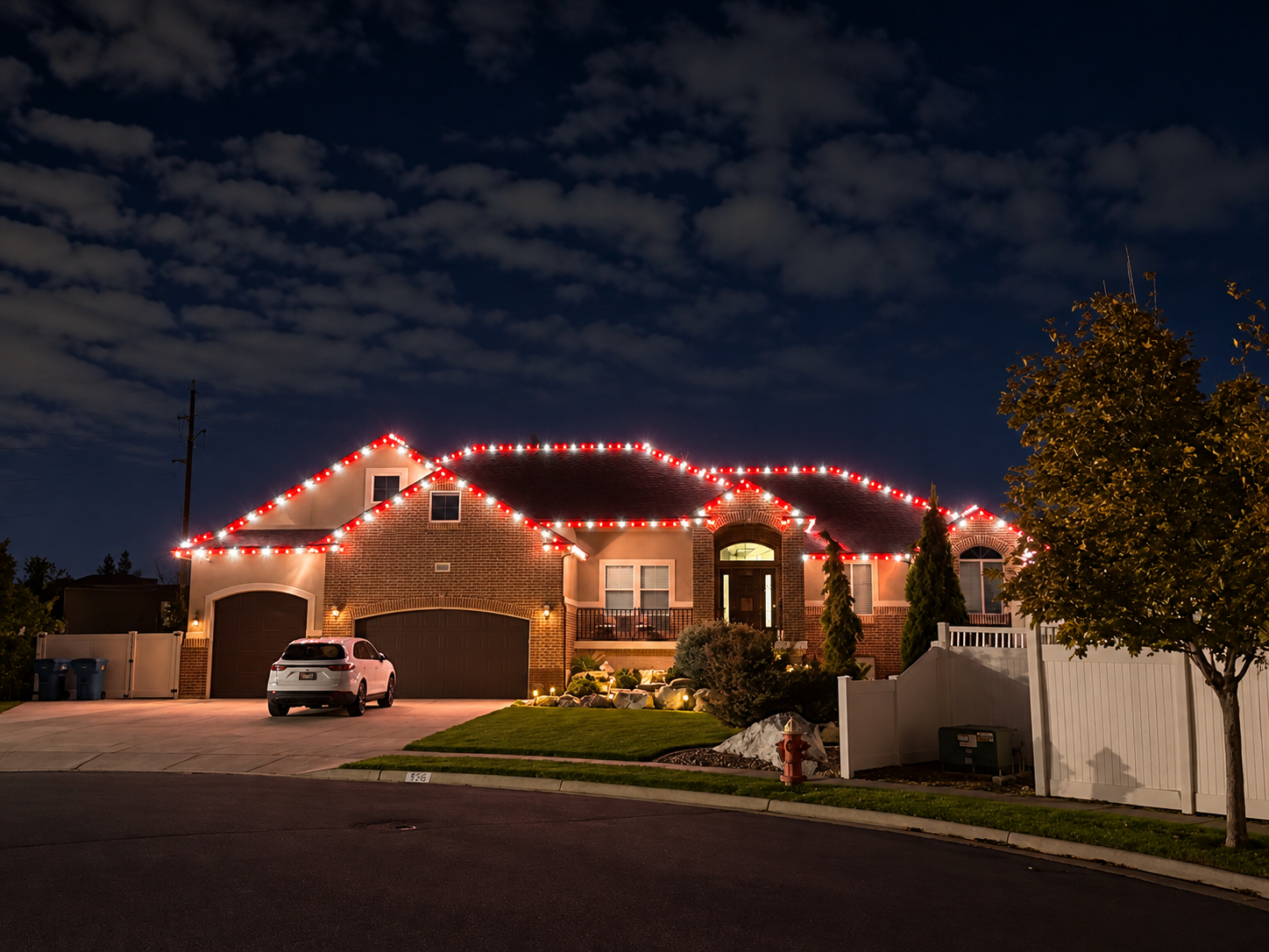 Red Christmas lights outlining a home and roofline at night