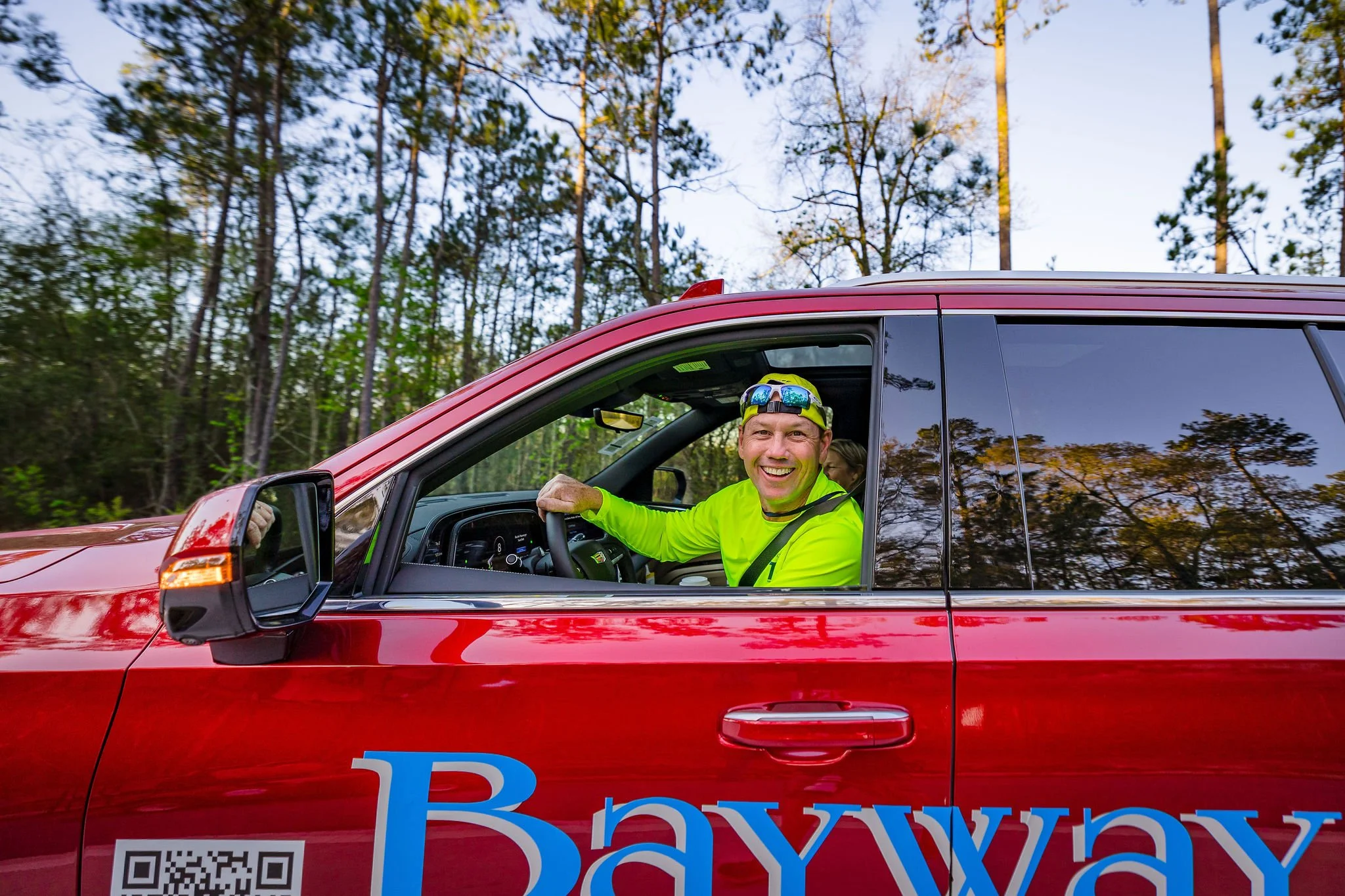 A smiling member of The Woodlands Marathon race team inside a course vehicle