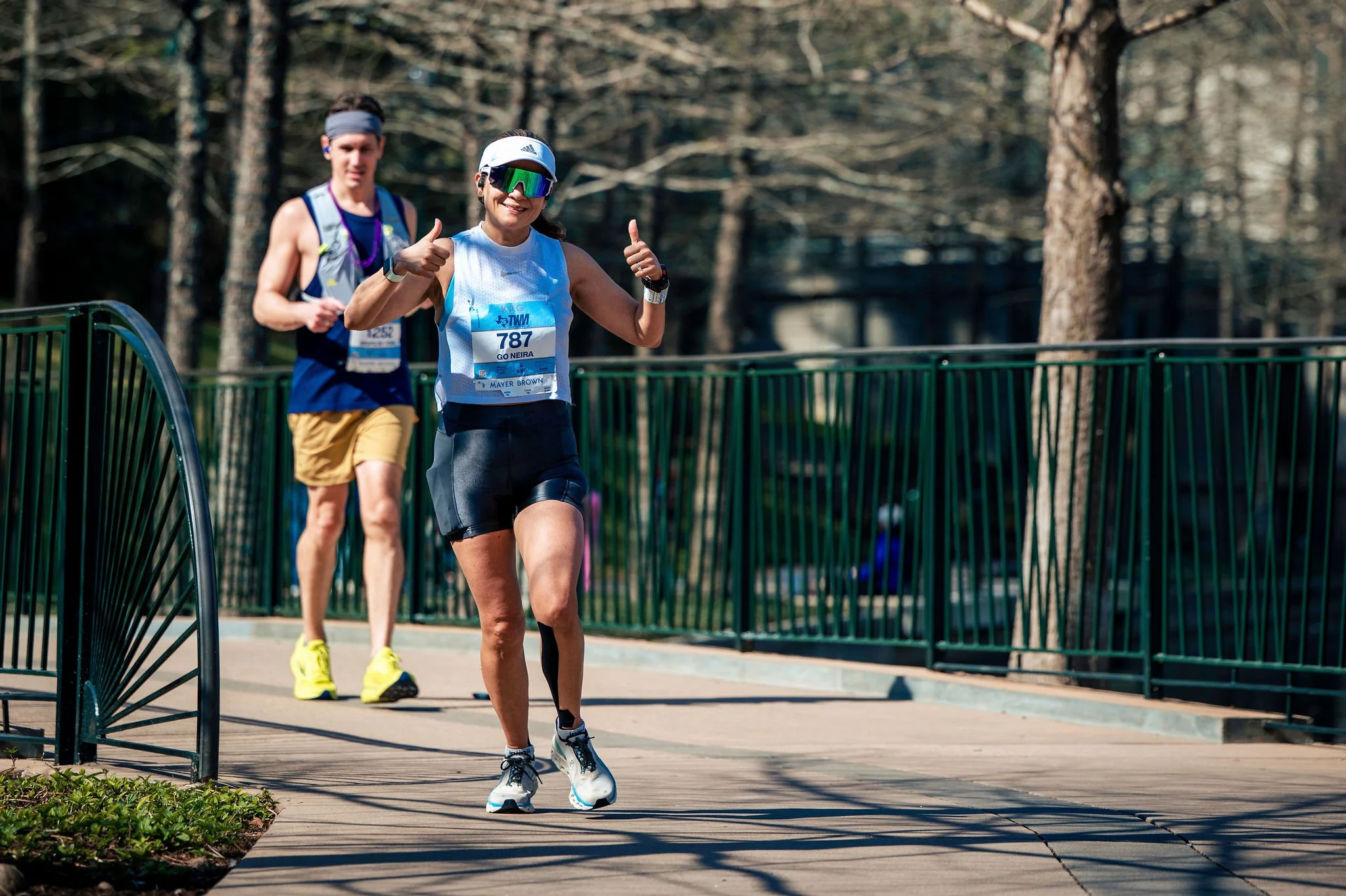 Runners moving together beside The Woodlands Waterway