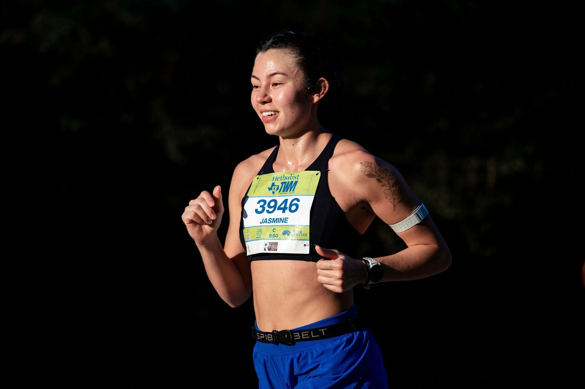 A woman runner racing toward the finish in The Woodlands