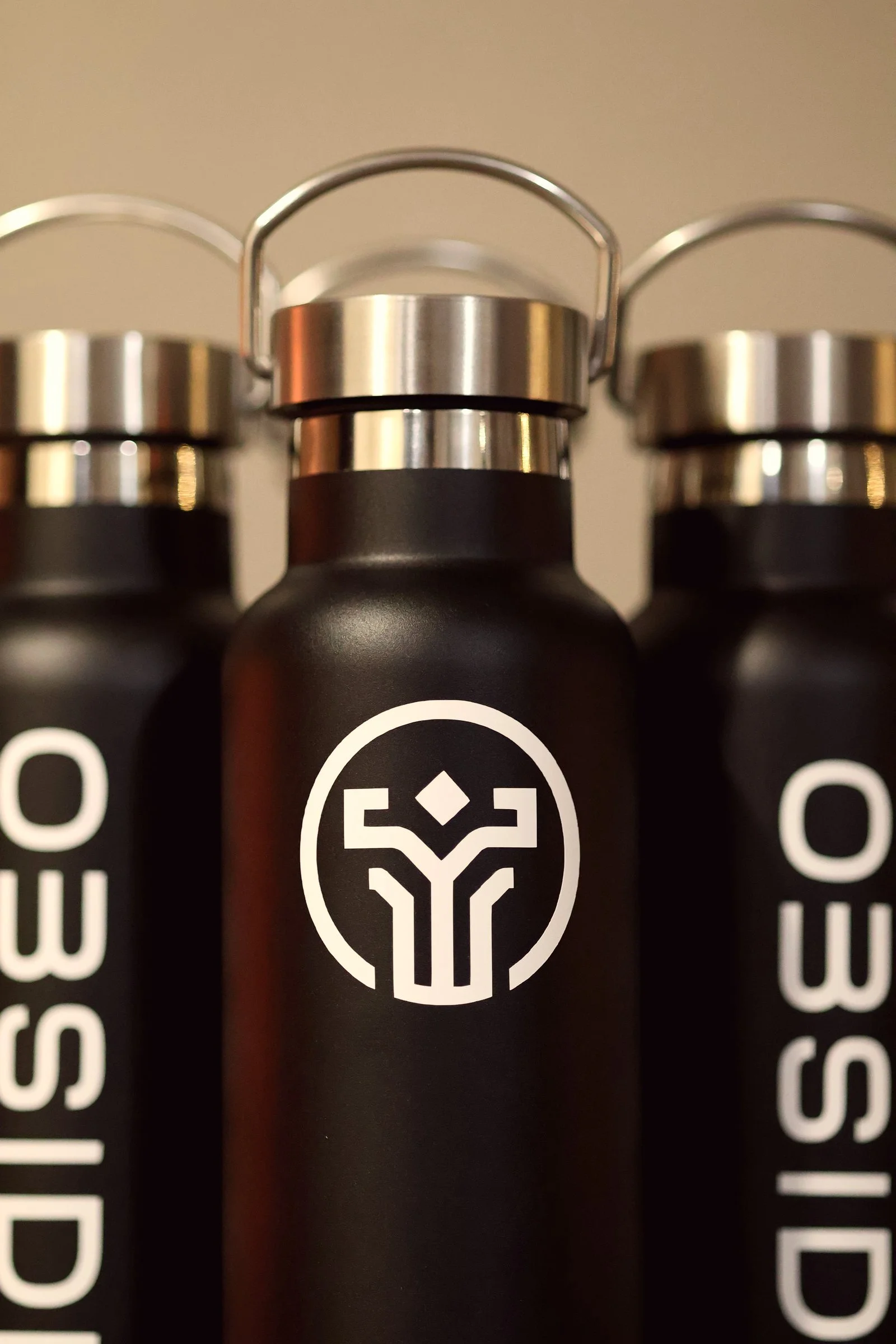 Product photography of black Obsidian Fitness water bottles with white logo, shot by Poppy House Media
