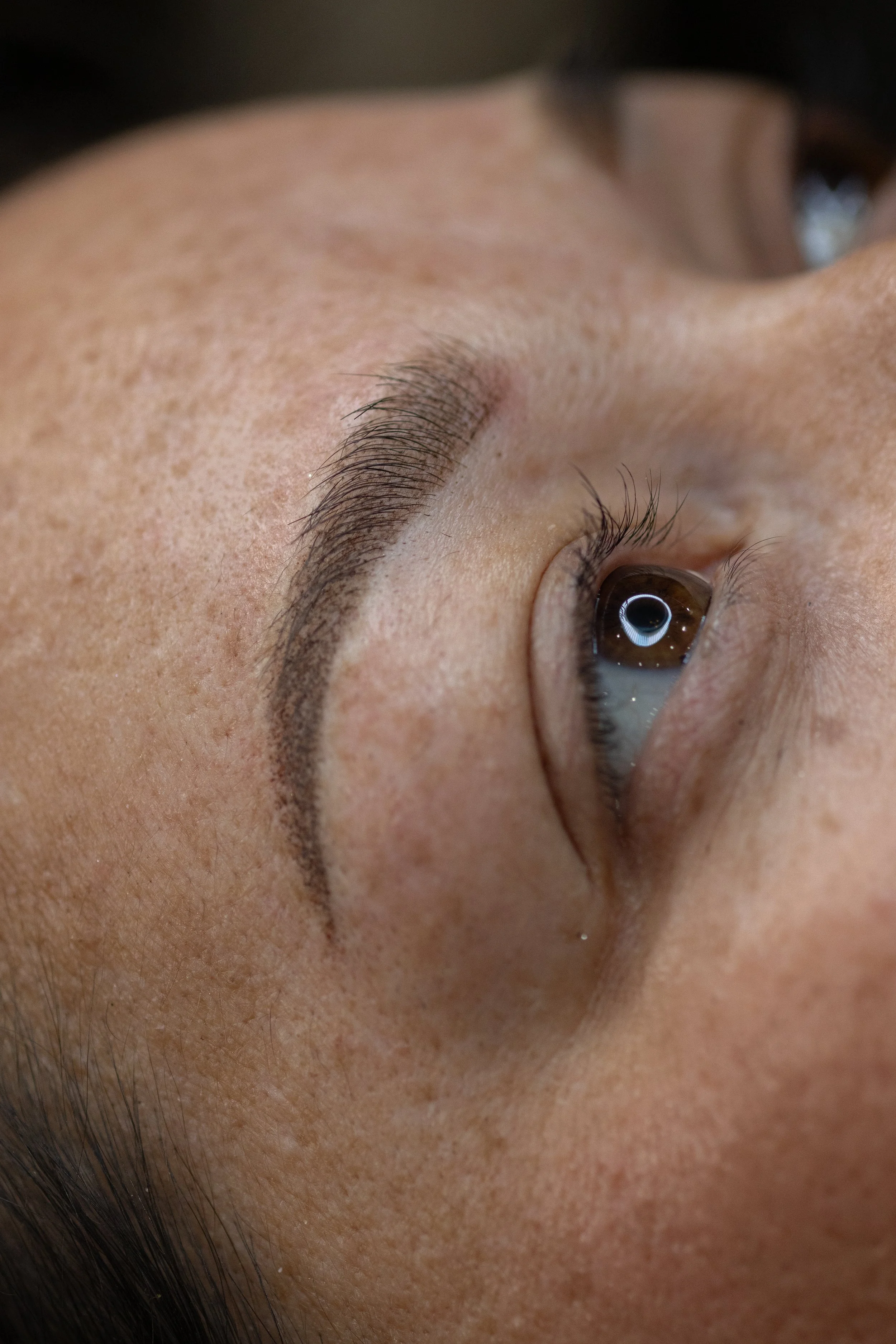 Close-up beauty photograph of an eye and groomed brow, shot for an aesthetics brand by Poppy House Media
