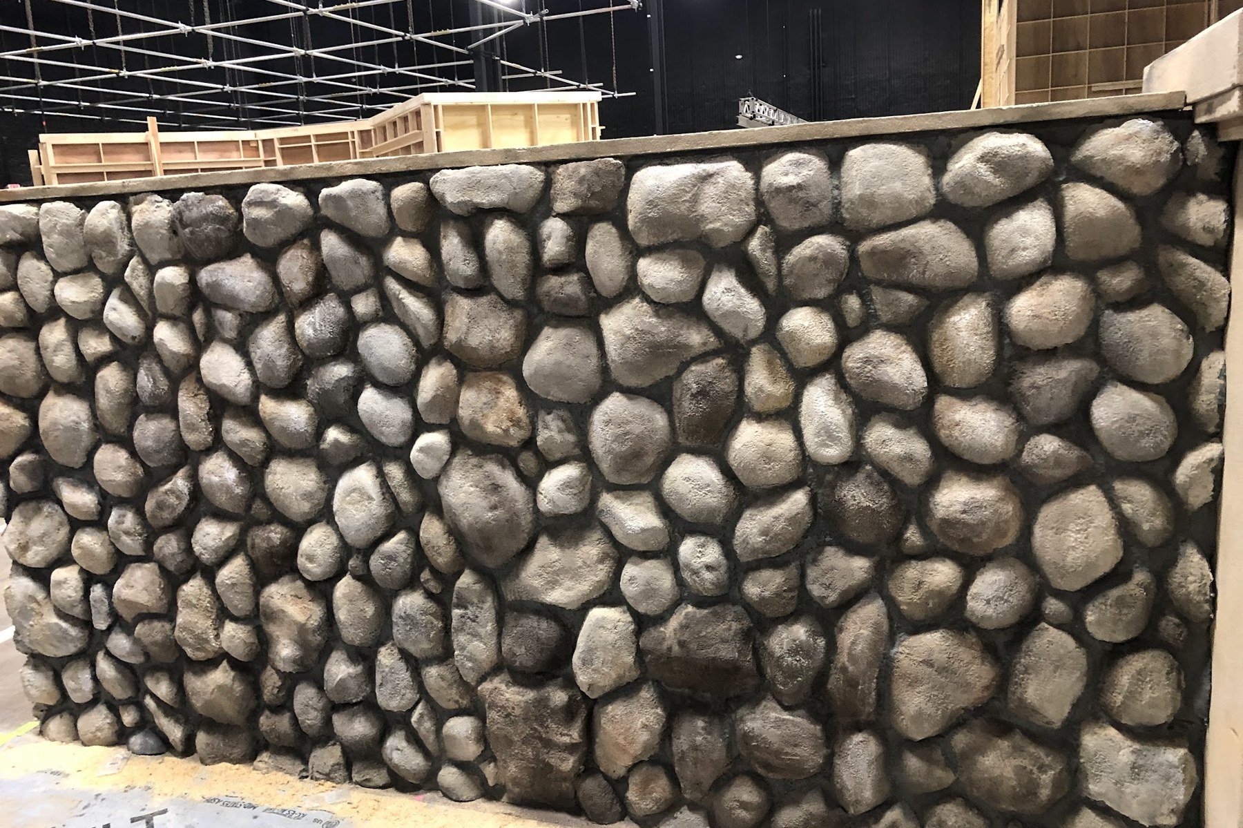 Stone skin wall panel hand-painted to look like real rounded river stone and mortar