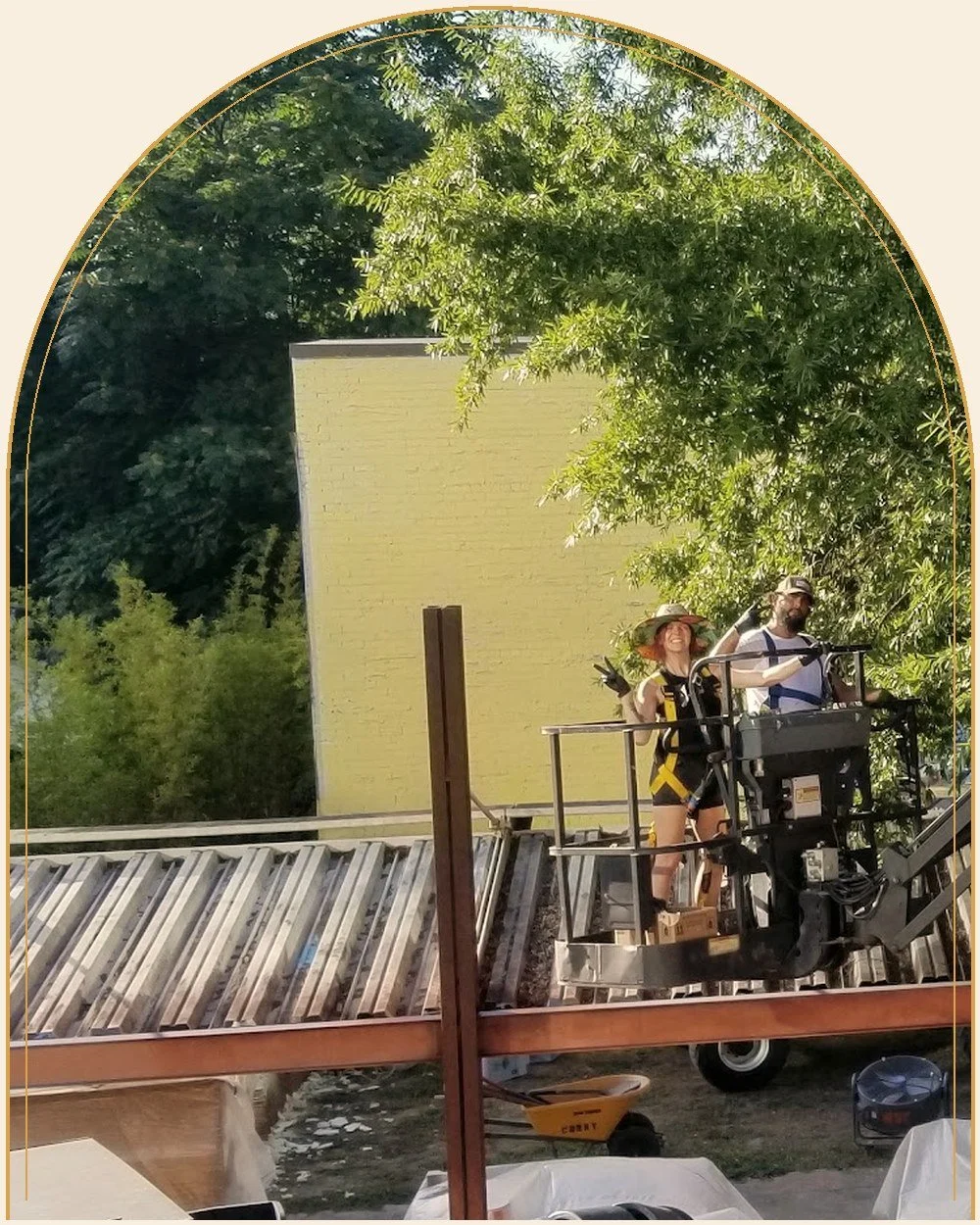 Specialty finisher Mallory Curry in a condor lift beside rust-toned steel framing on an Atlanta street set
